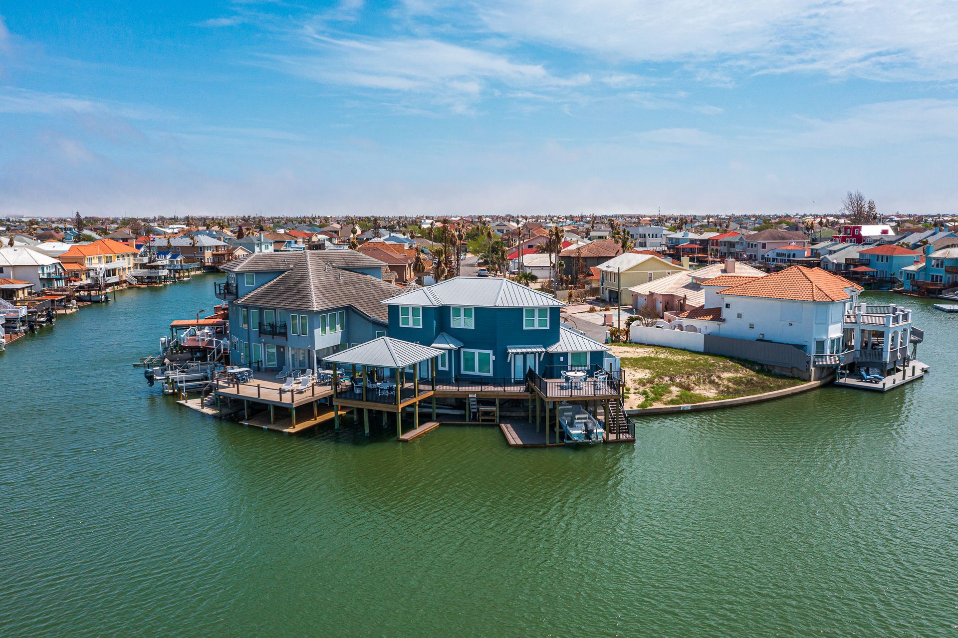 An aerial view of a house on a small island in the middle of a body of water.