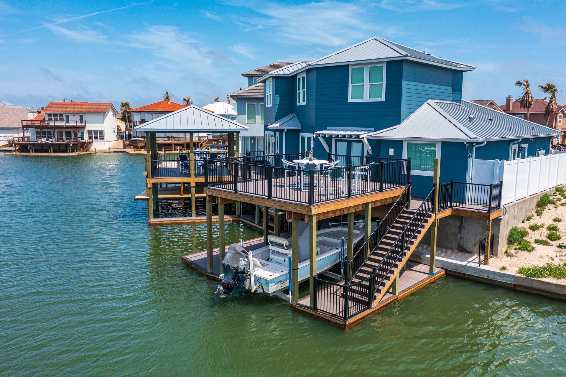 A house is sitting on top of a dock next to a body of water.