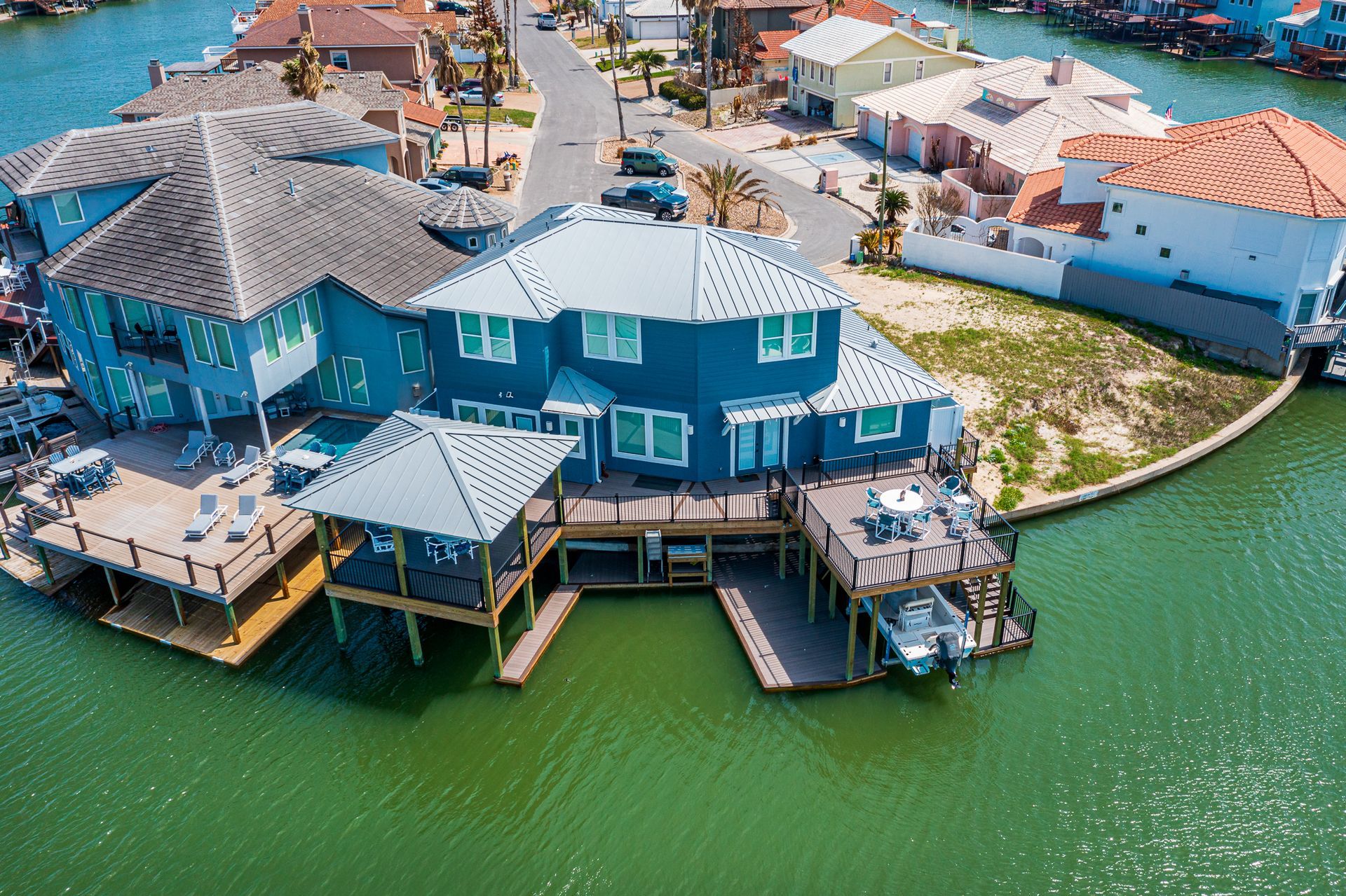 An aerial view of a house on a small island in the middle of a body of water.