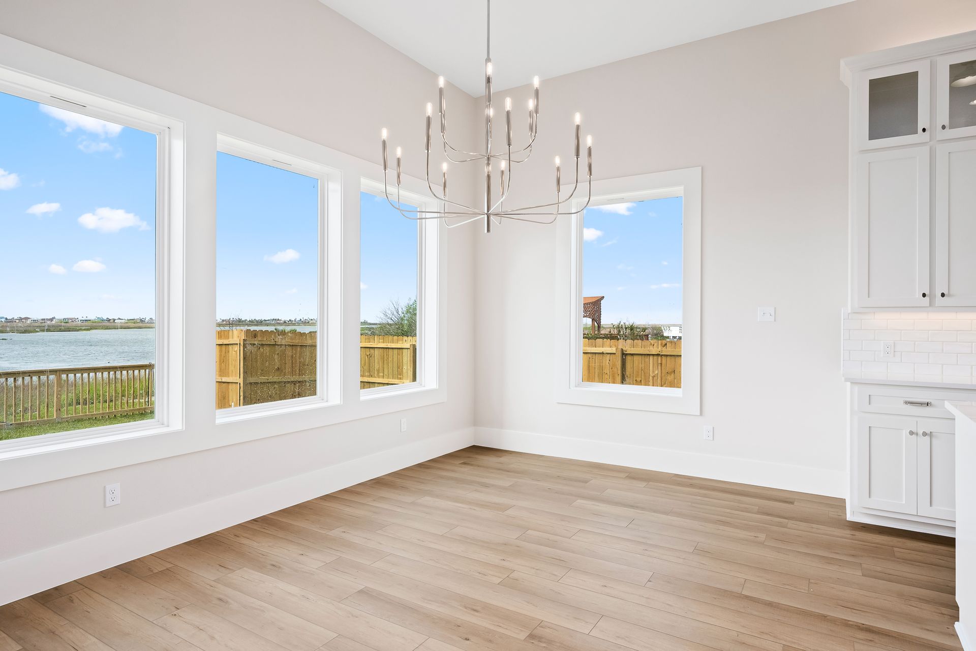 An empty room with lots of windows and a chandelier.