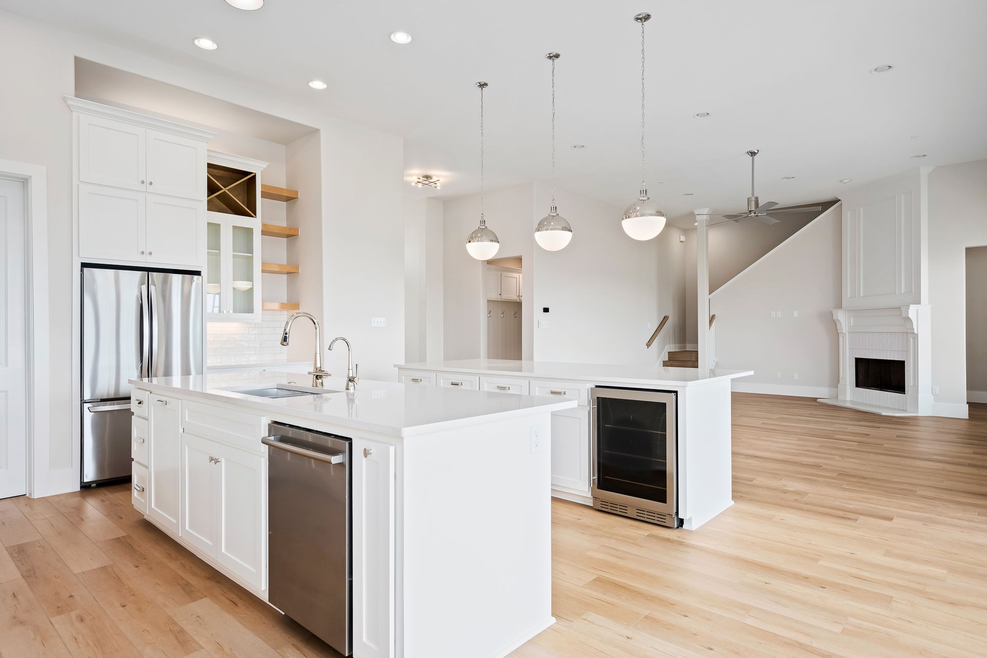A kitchen with white cabinets , stainless steel appliances , and hardwood floors.
