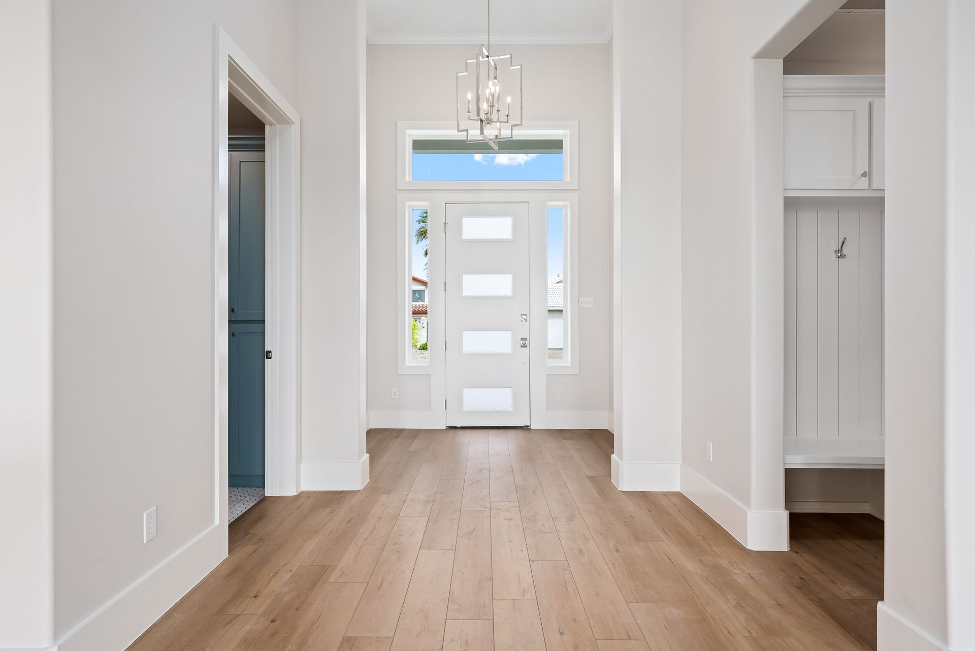 An empty hallway with hardwood floors and a white door.