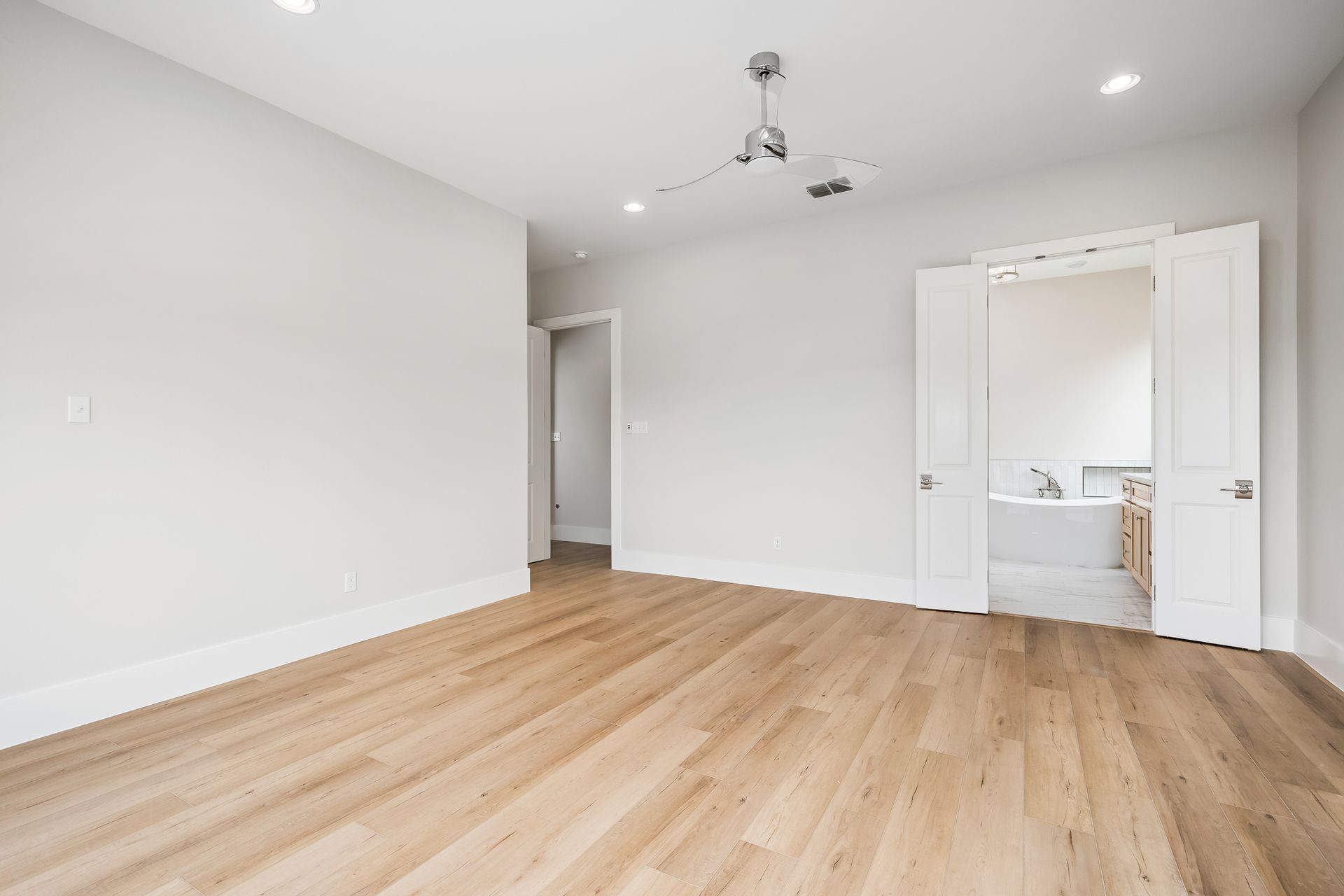An empty room with hardwood floors and white walls