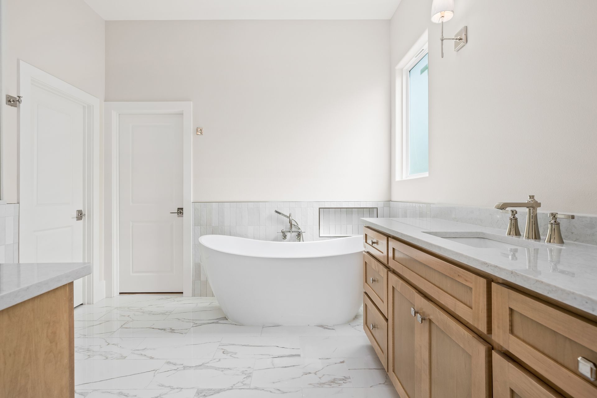 A bathroom with a tub , sink , and cabinets.