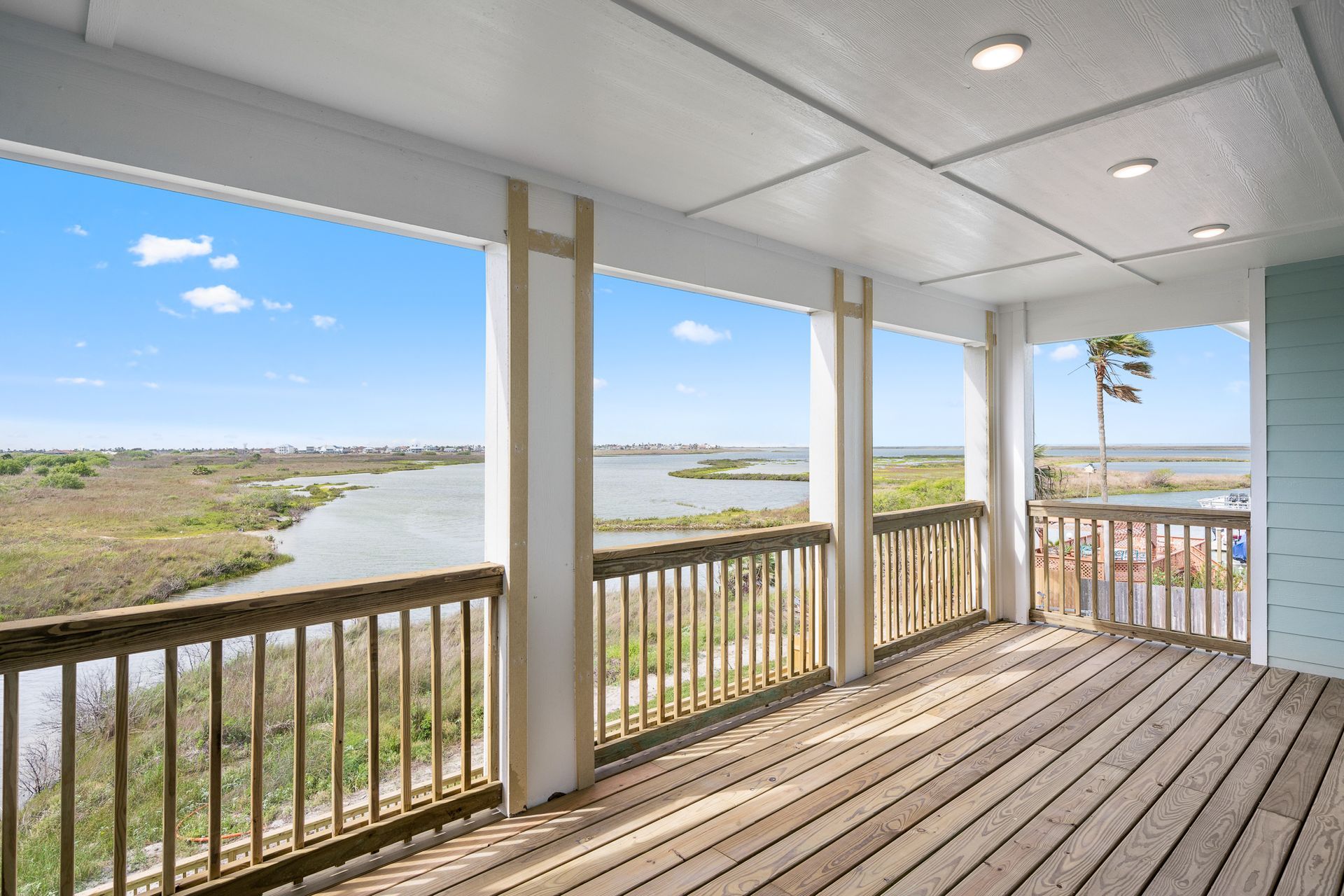 A large wooden deck with a view of a body of water.