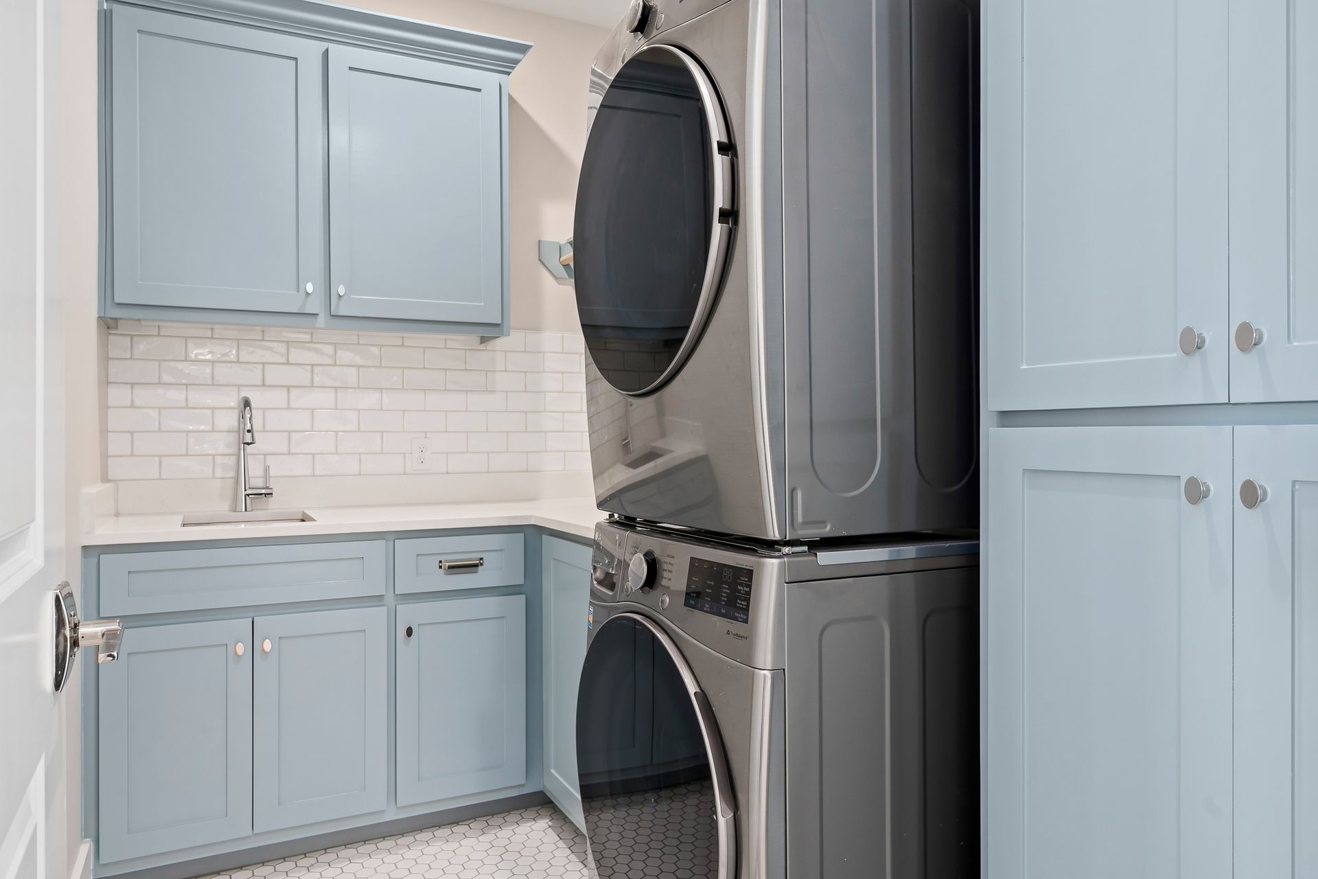 A laundry room with a washer and dryer stacked on top of each other.