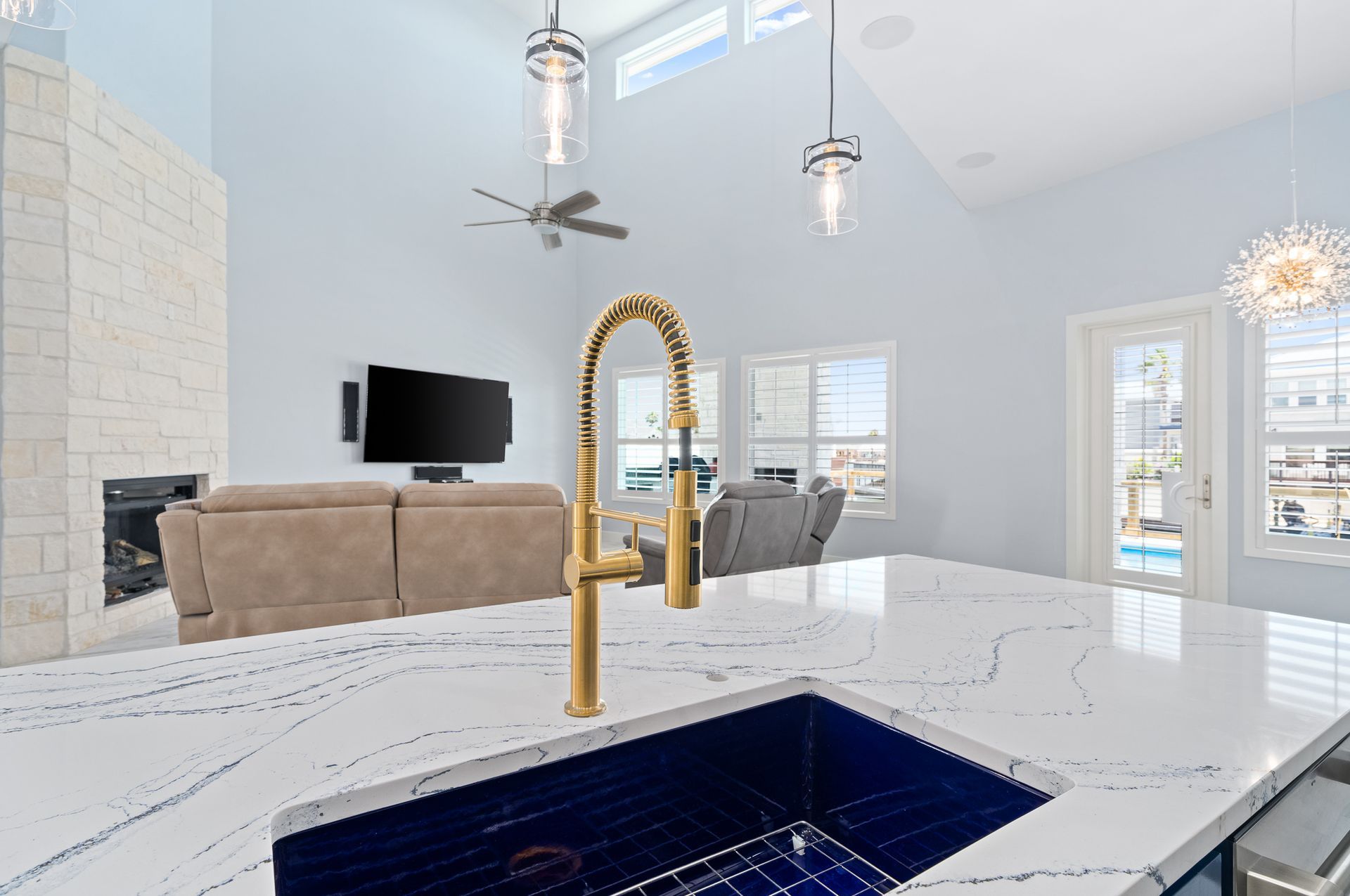 A kitchen with a blue sink and a gold faucet.