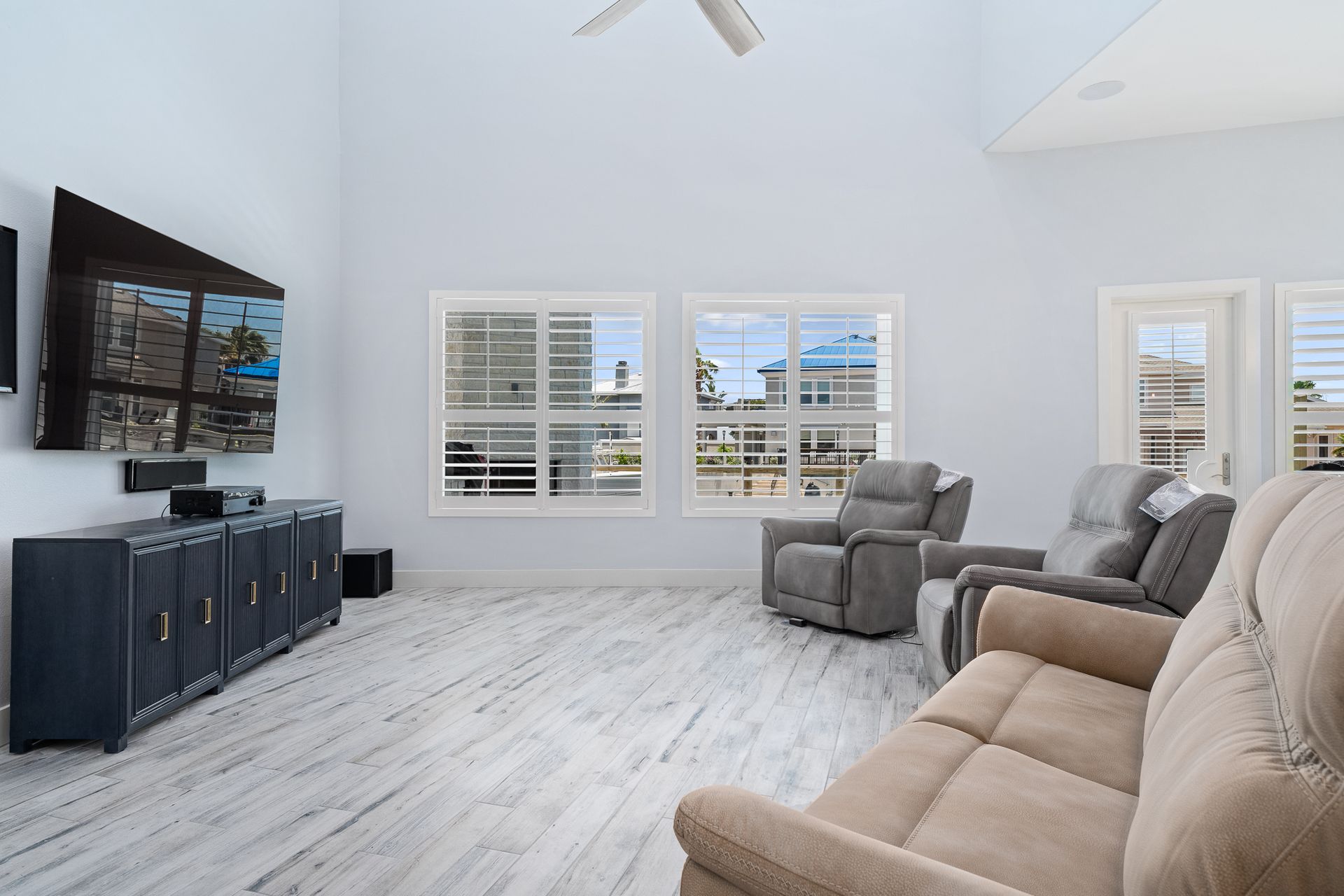 A living room with a couch and chairs and a flat screen tv