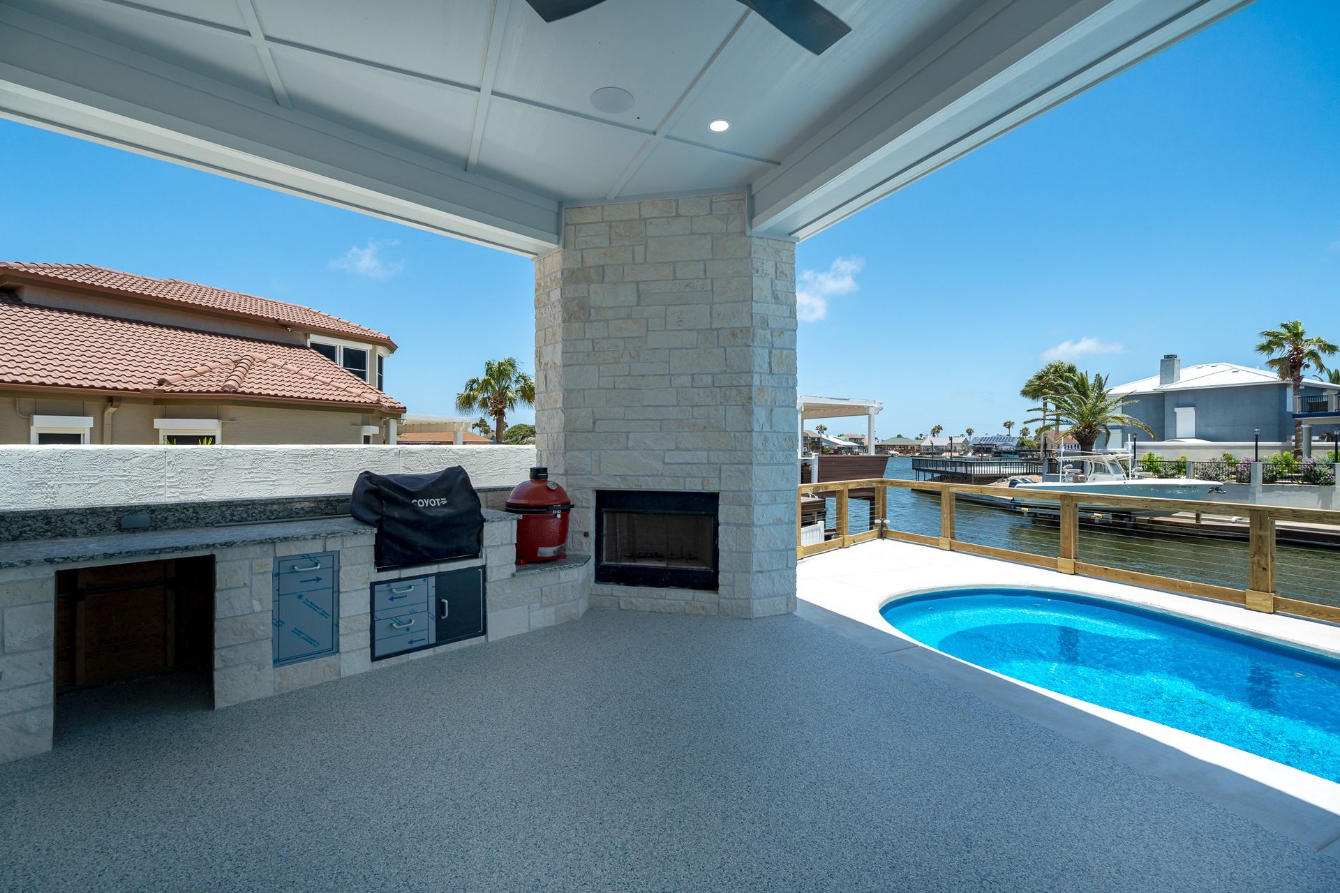 A patio with a fireplace and a swimming pool