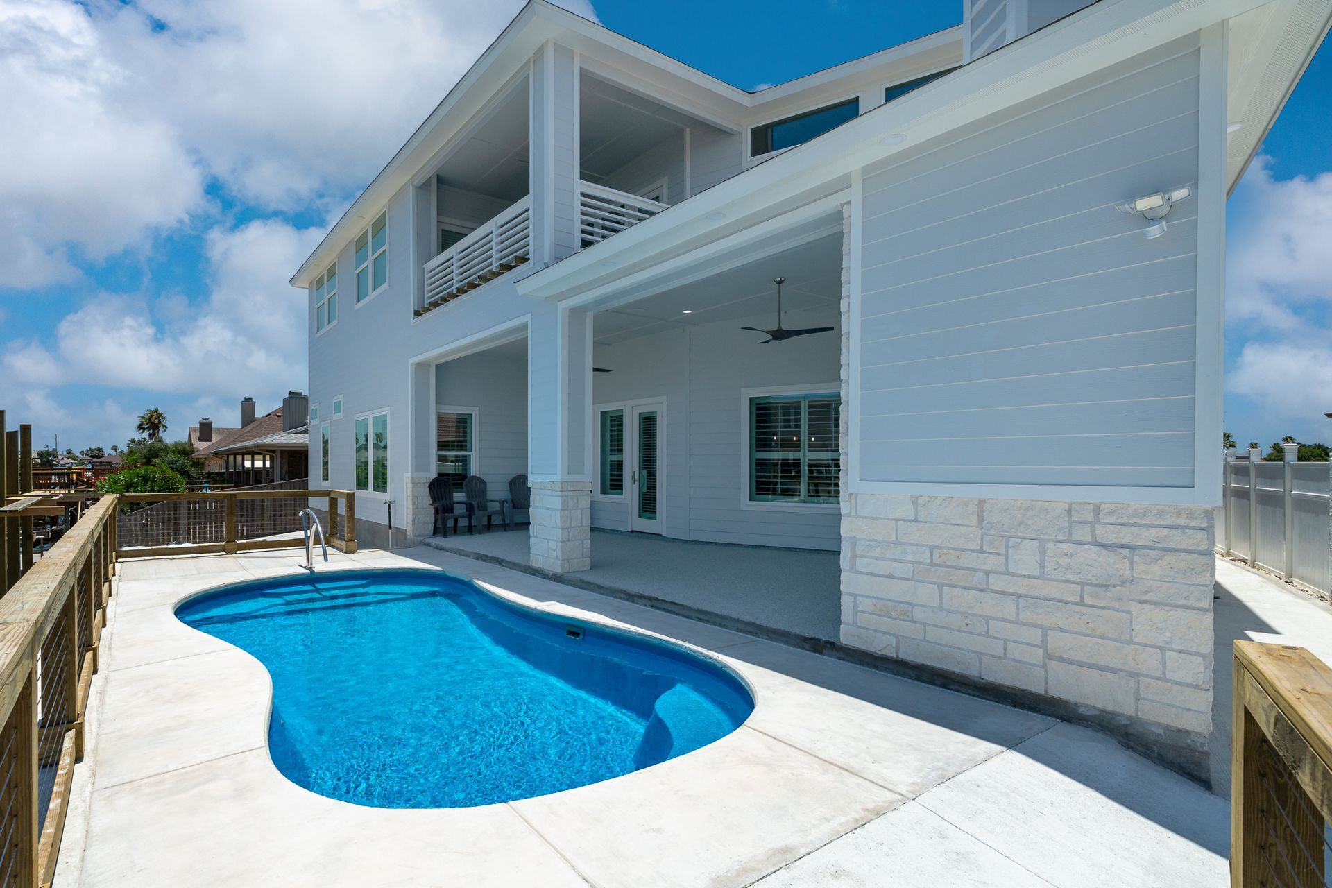 A large white house with a swimming pool in front of it