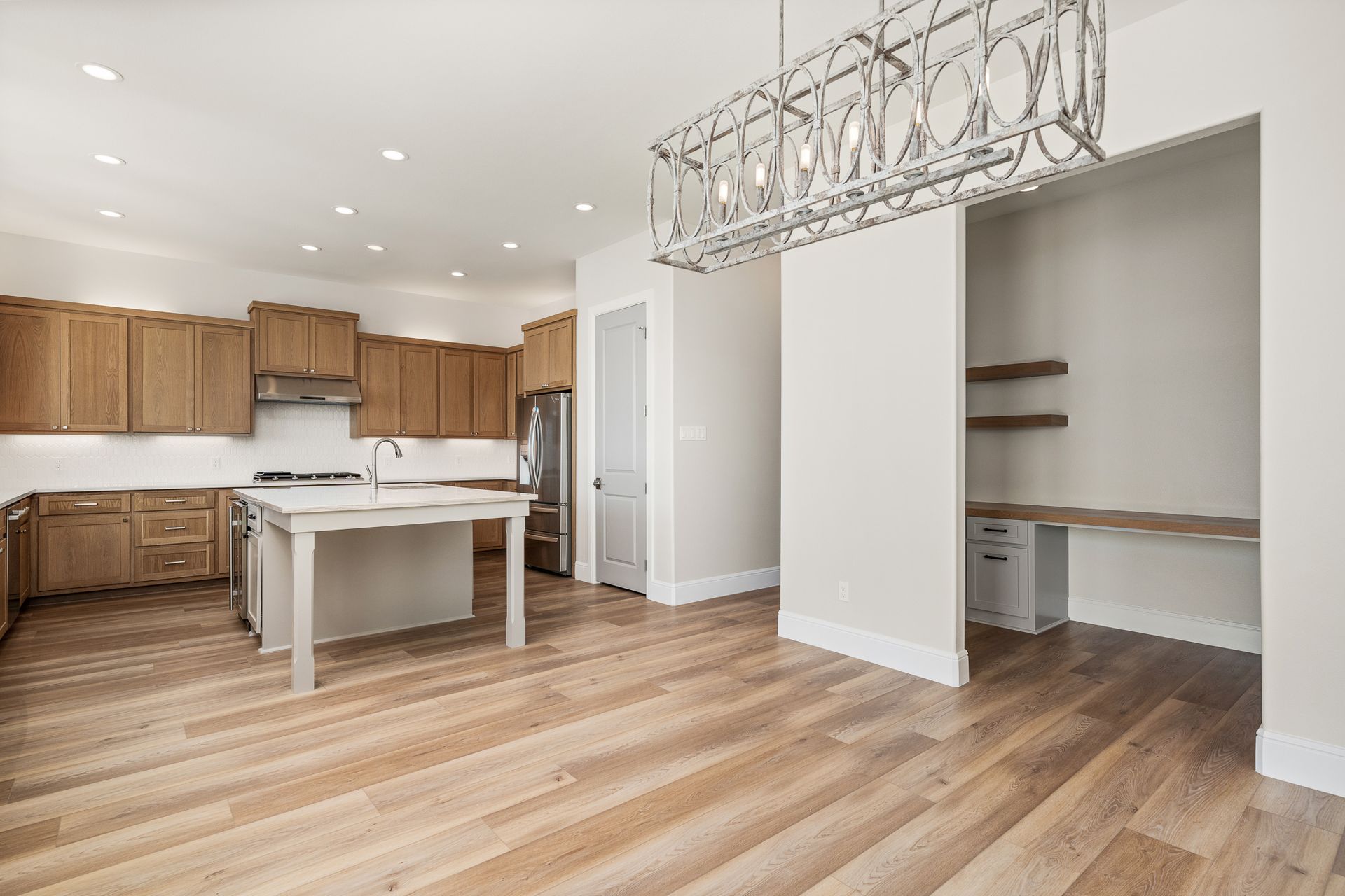 A kitchen with wooden cabinets and a large island in the middle of the room.