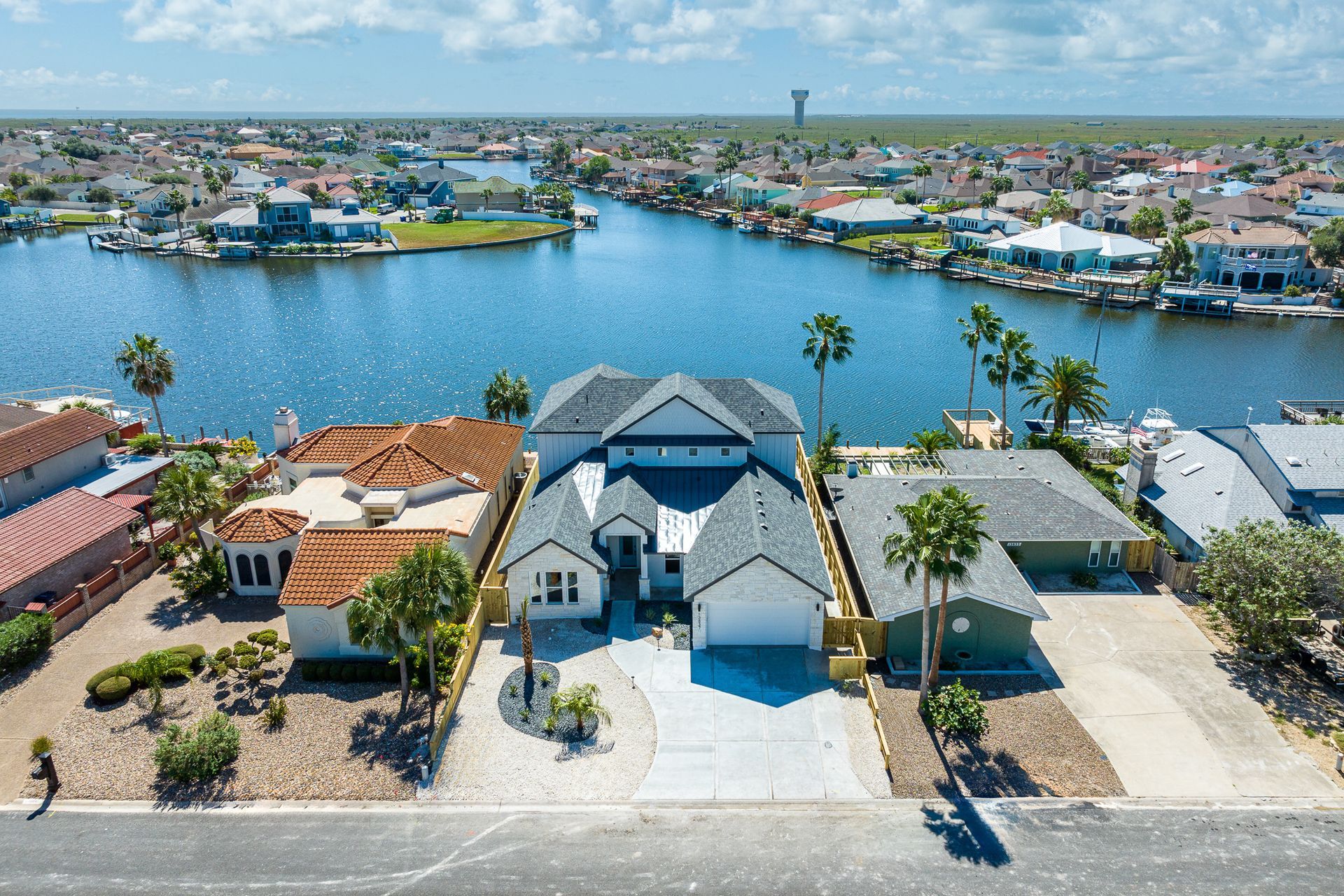 An aerial view of a house next to a body of water.