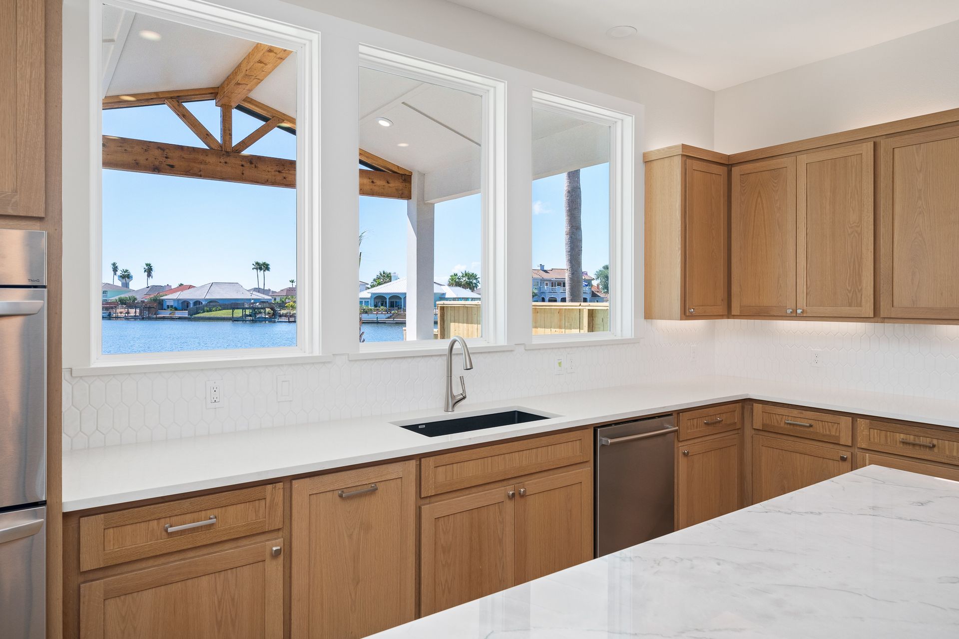 A kitchen with wooden cabinets and white counter tops
