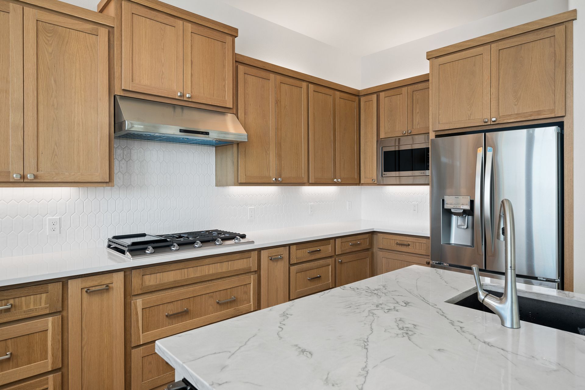 A kitchen with wooden cabinets and white counter tops
