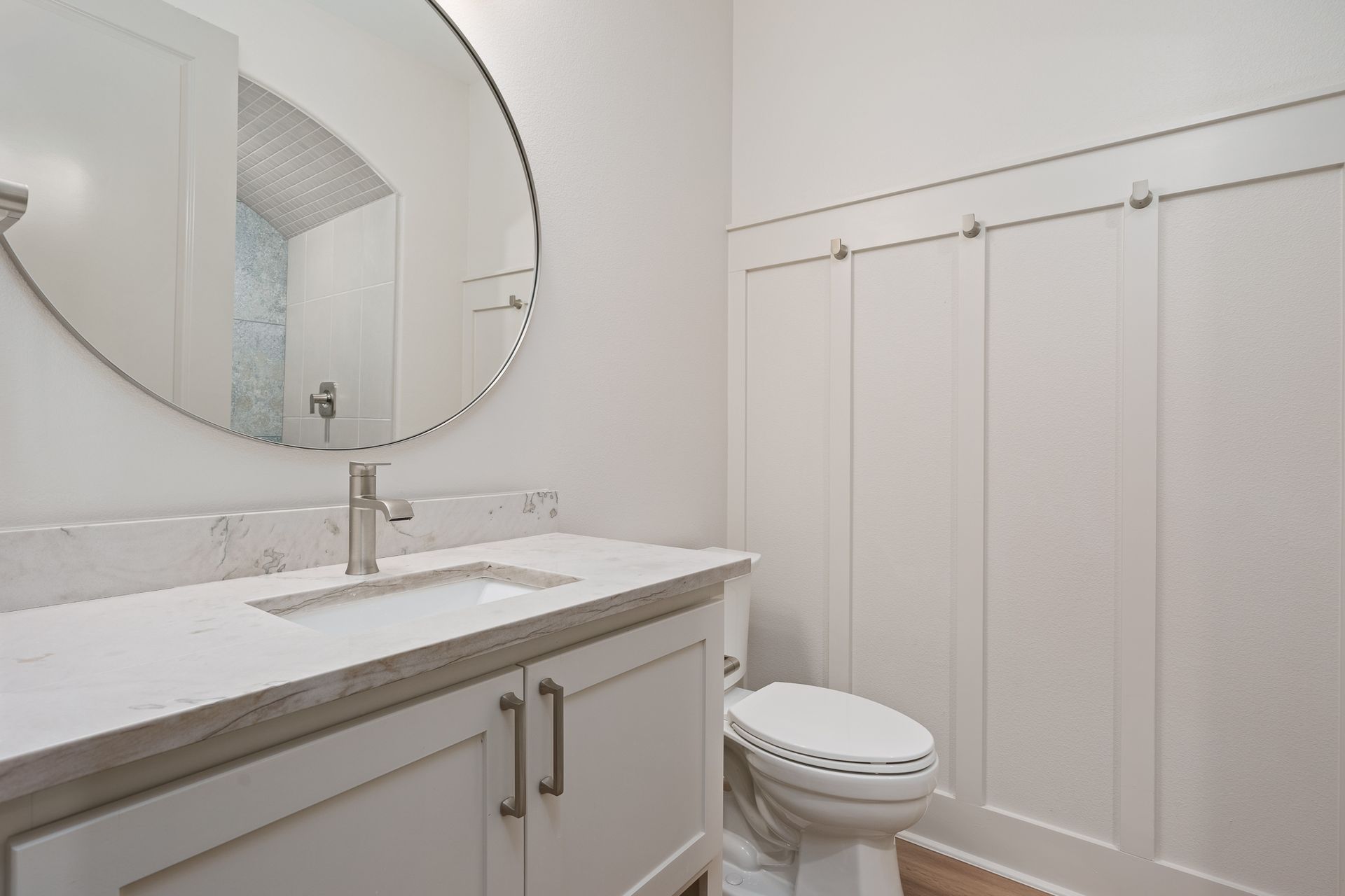 A bathroom with a sink , toilet and mirror.