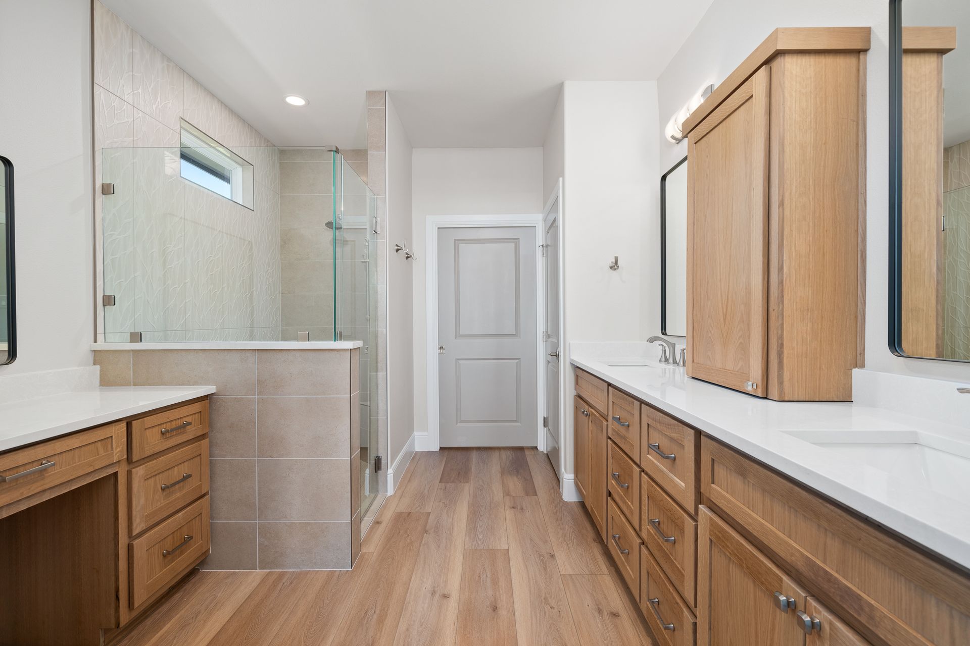 A bathroom with two sinks and a walk in shower.