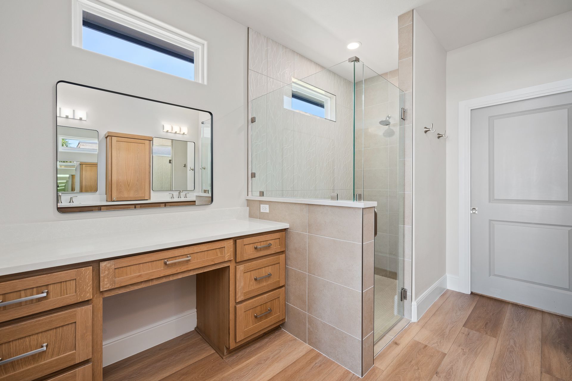A bathroom with a walk in shower and a vanity.