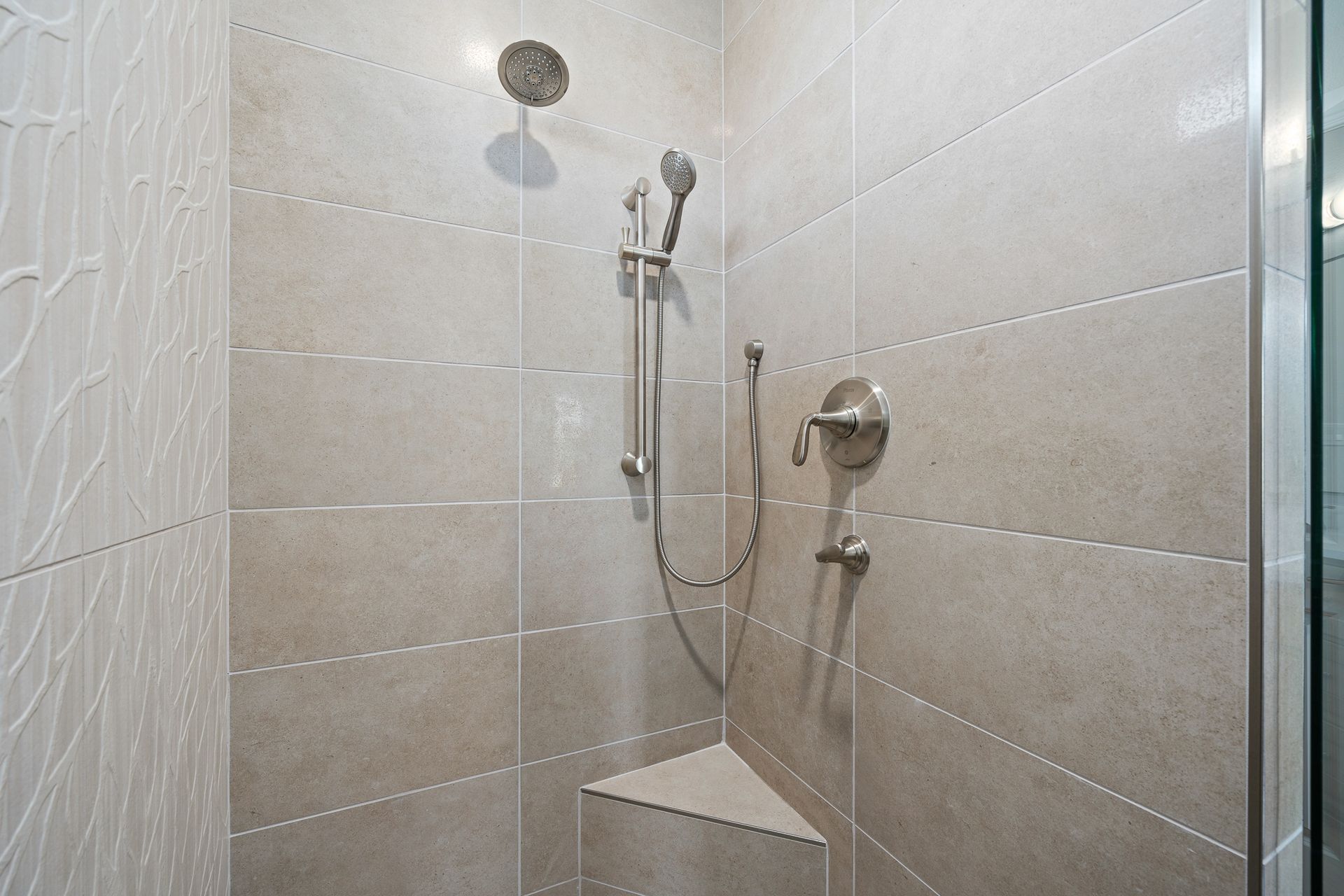 A shower with a glass door and a shower head