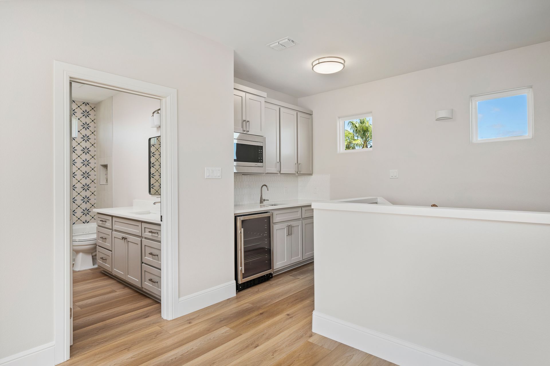A kitchen with white cabinets , stainless steel appliances , and hardwood floors.