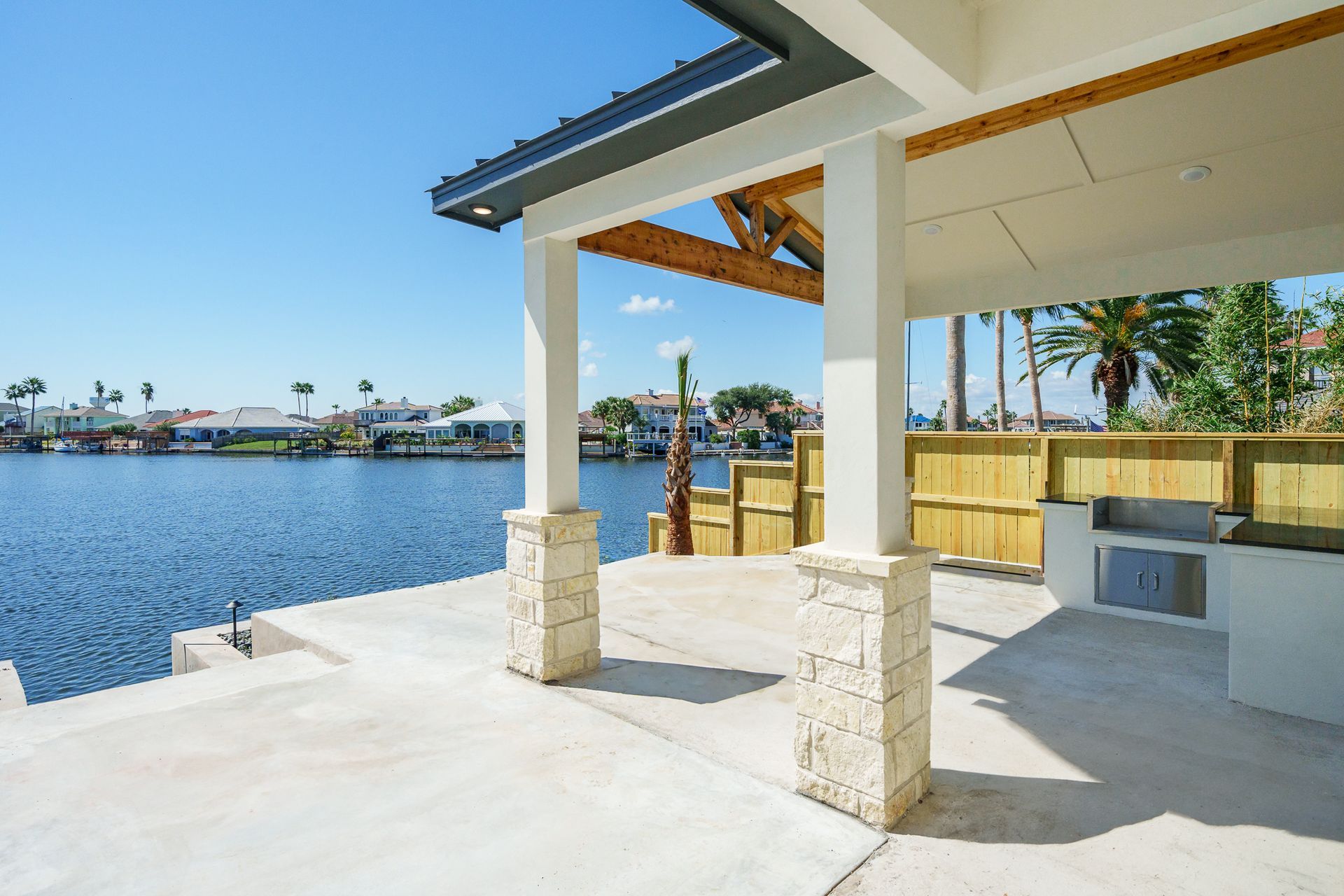 A patio with a view of a lake and a kitchen.