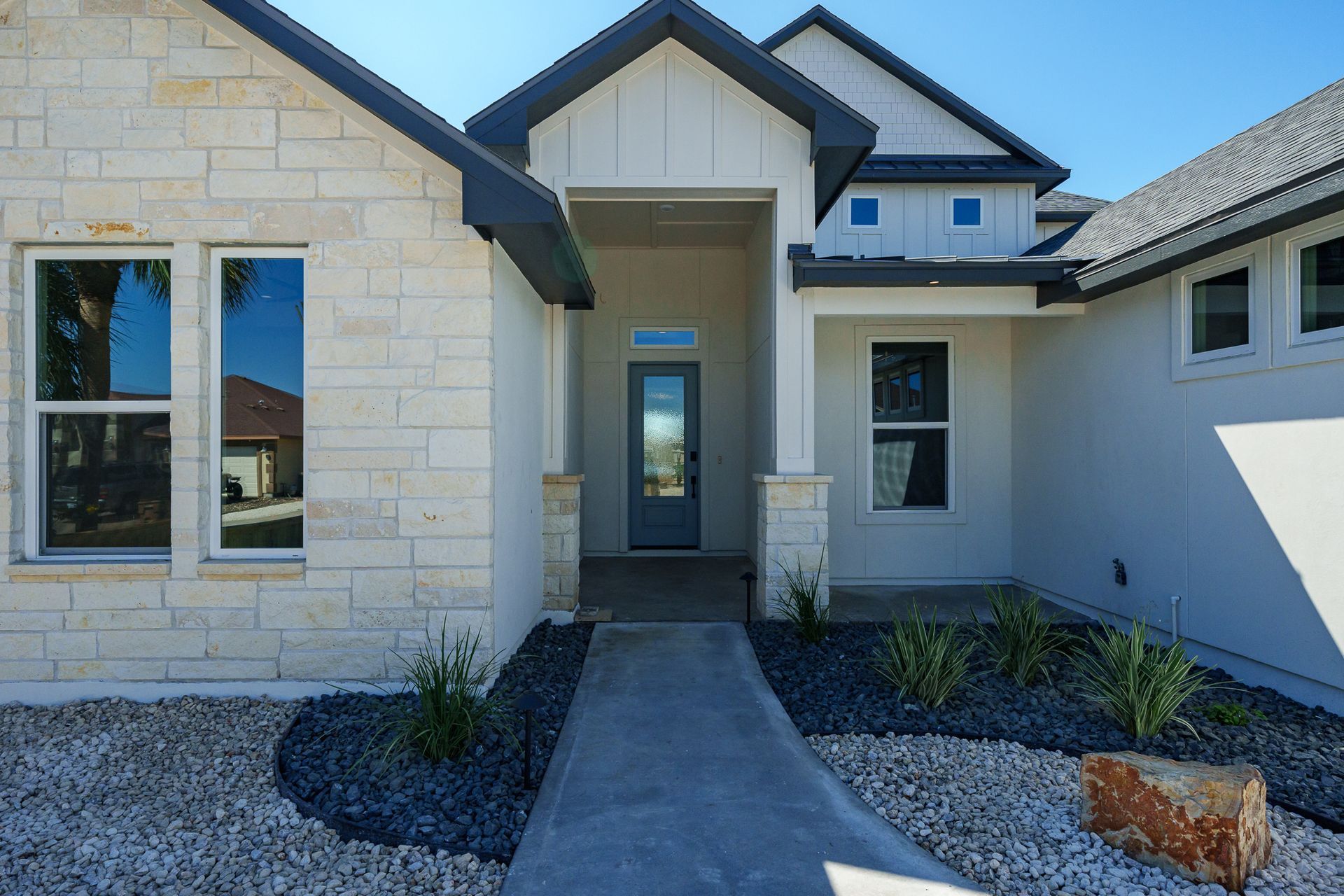 A white house with a walkway leading to the front door