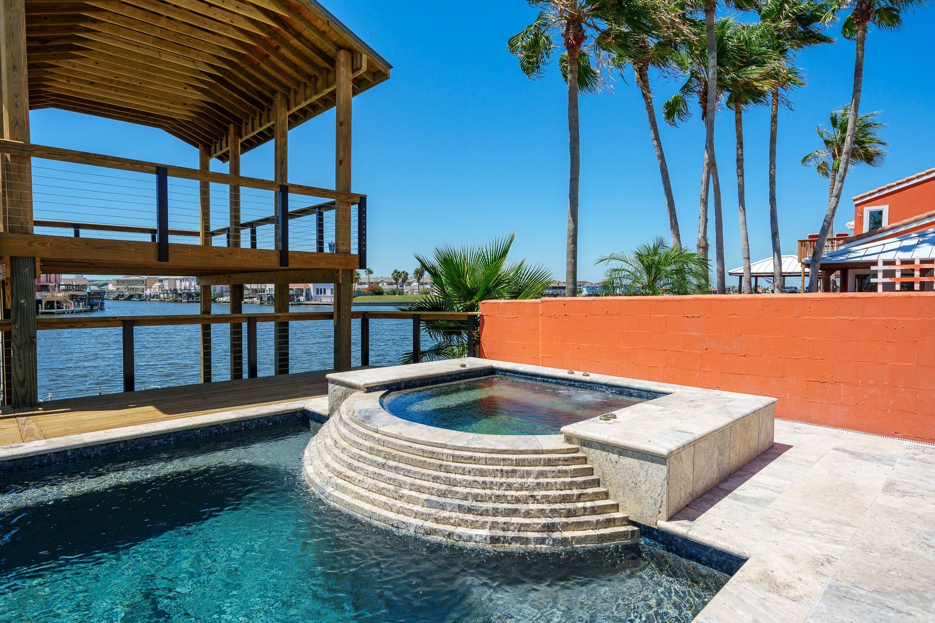 A large swimming pool with a hot tub in the middle of it
