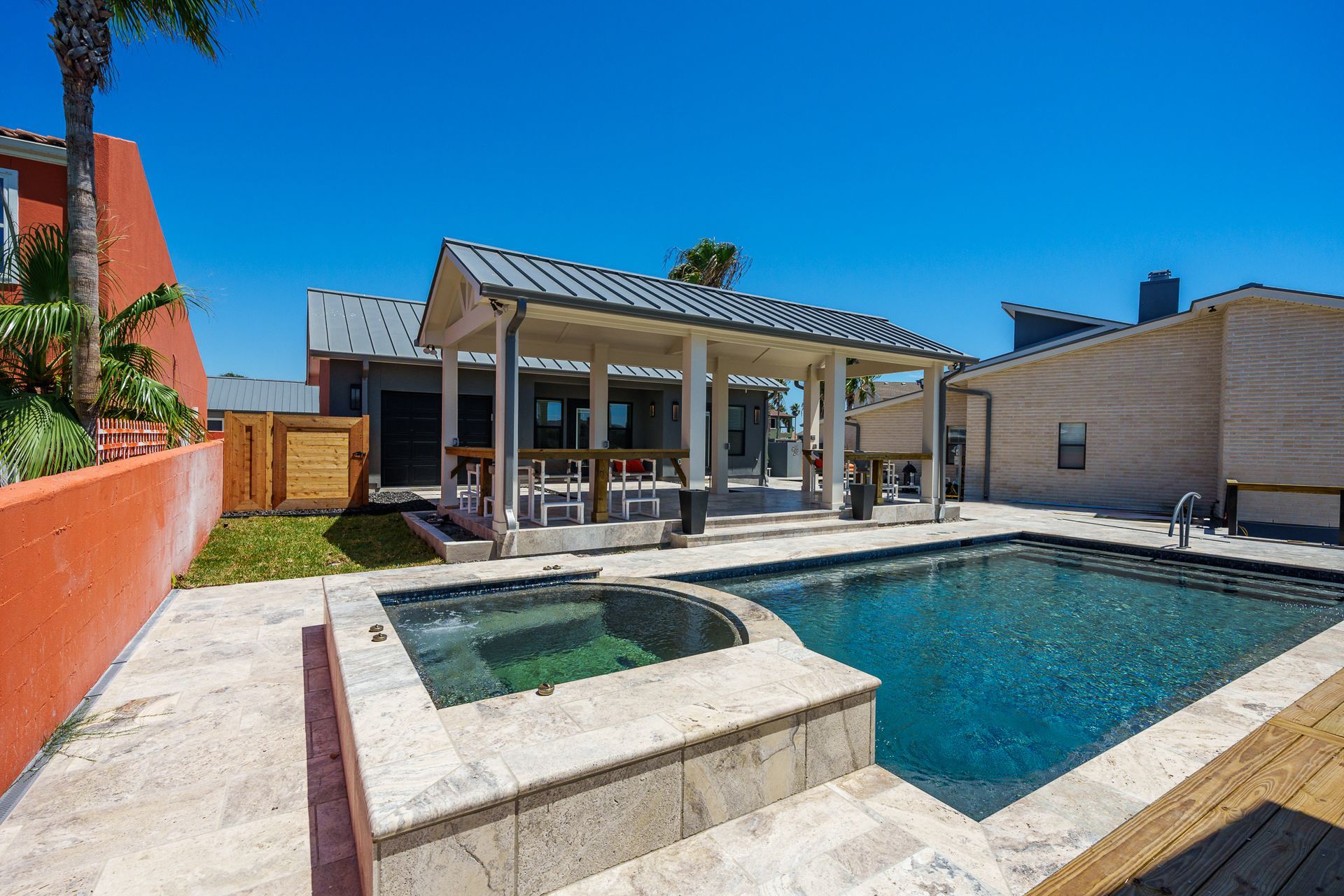 A large swimming pool with a hot tub next to it