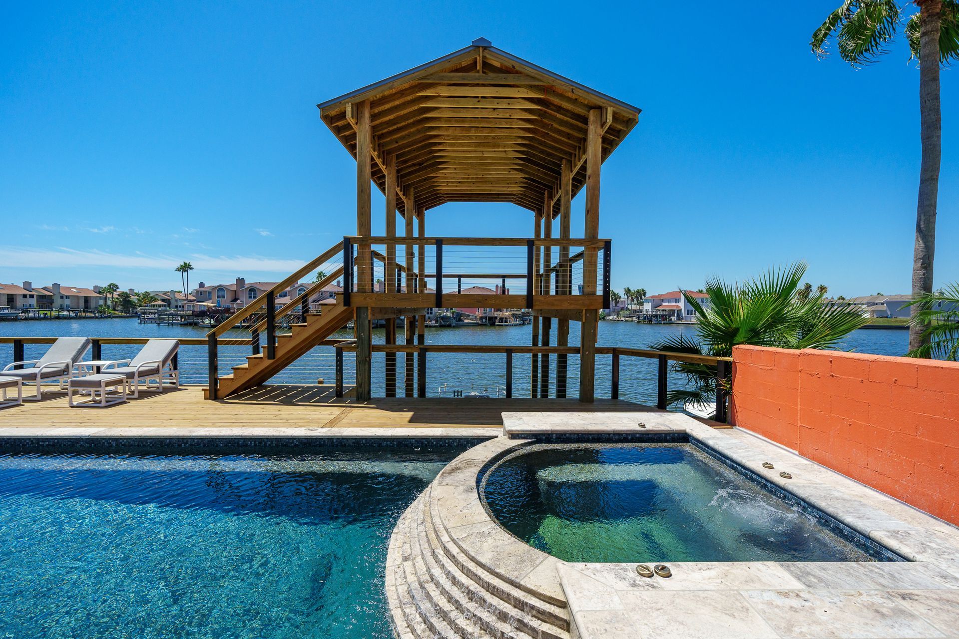 A swimming pool with a gazebo and a hot tub next to it.