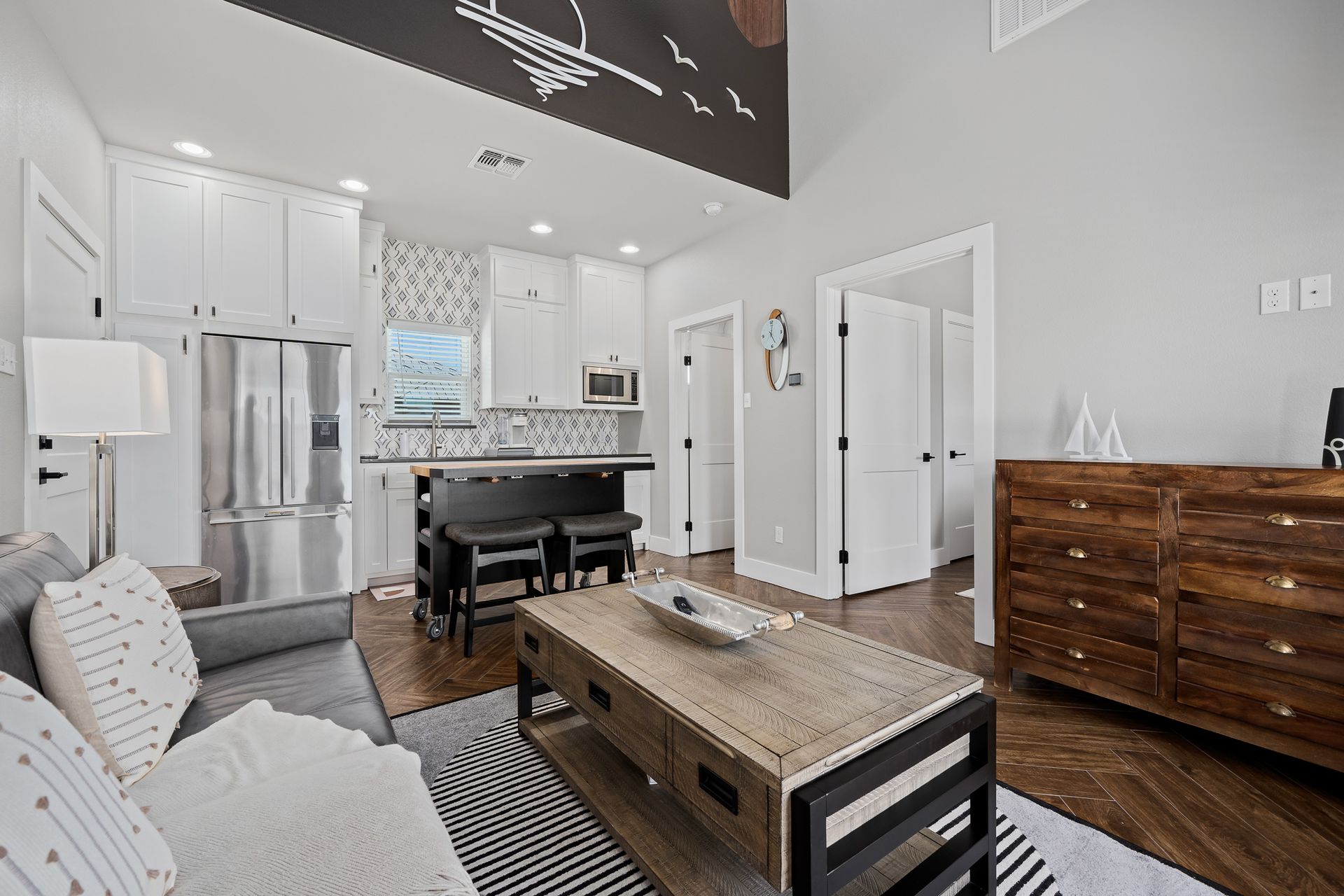 A living room with a couch , coffee table , and kitchen.