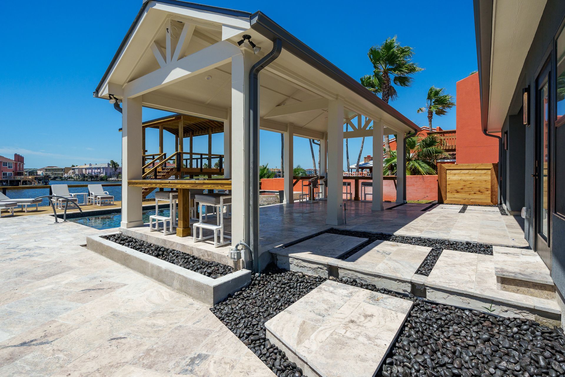 A large covered patio area with a swimming pool in the background.