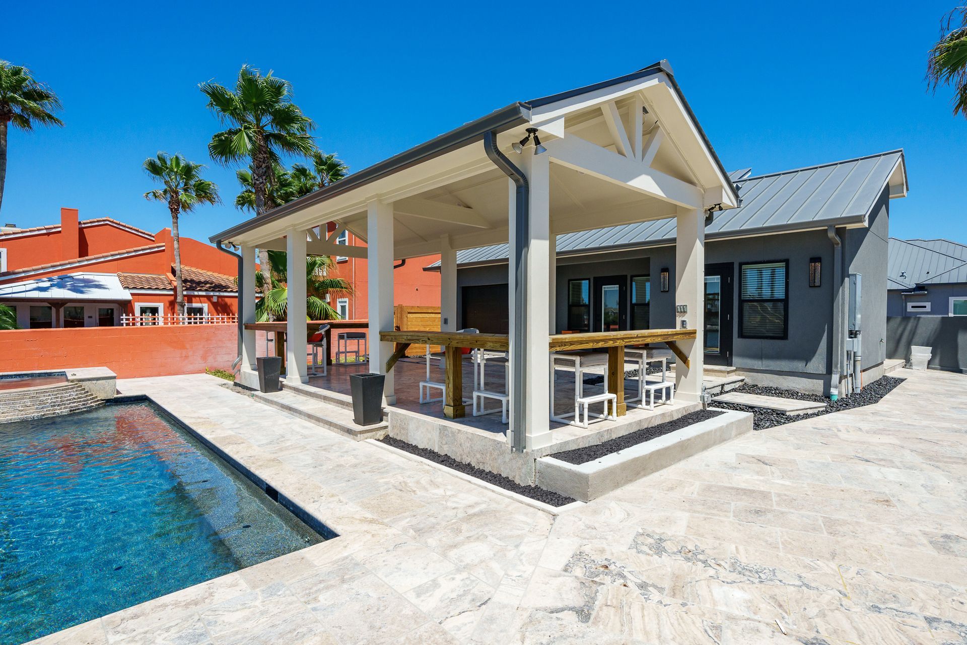 A house with a pool and a pavilion in front of it