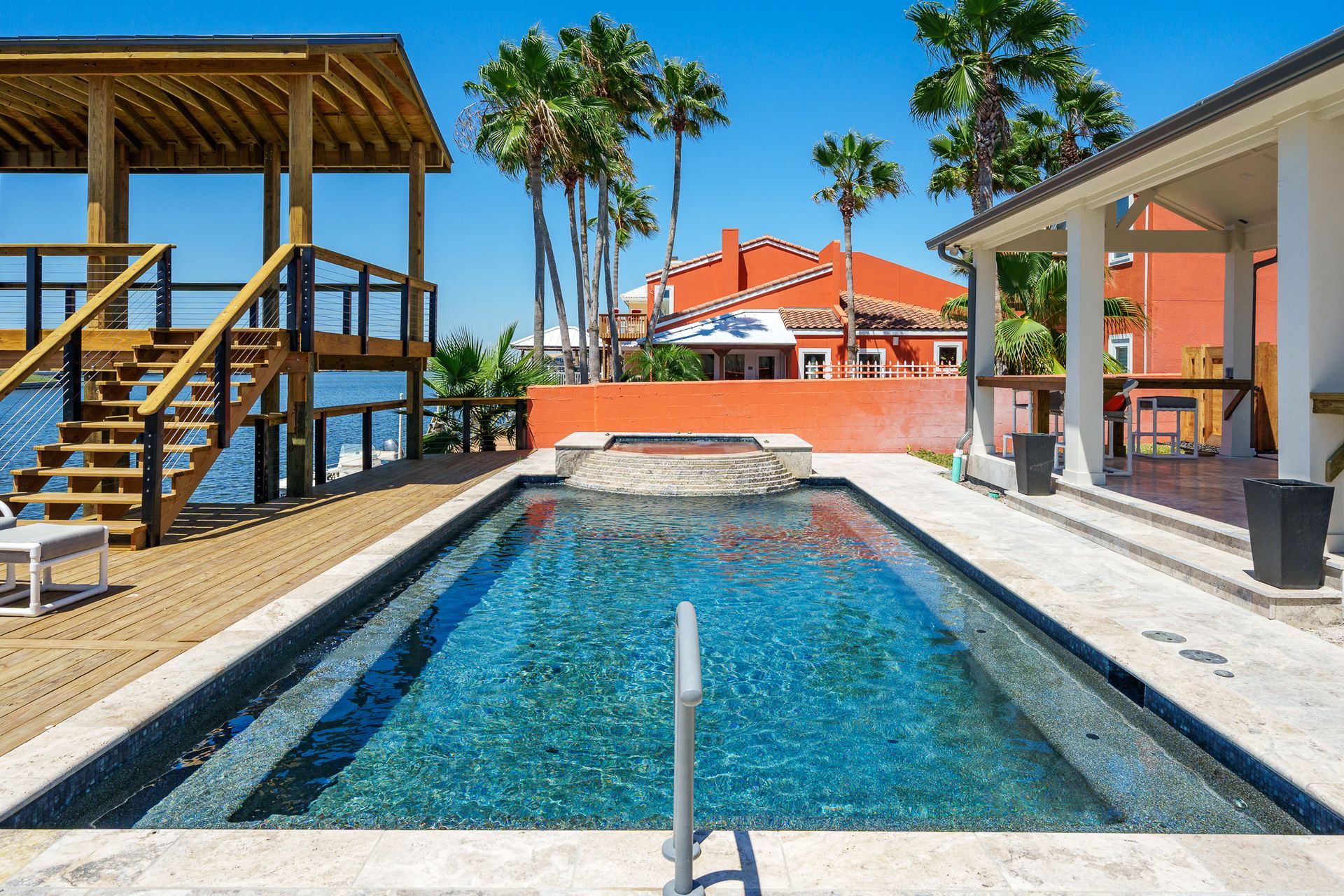 A large swimming pool with palm trees in the background