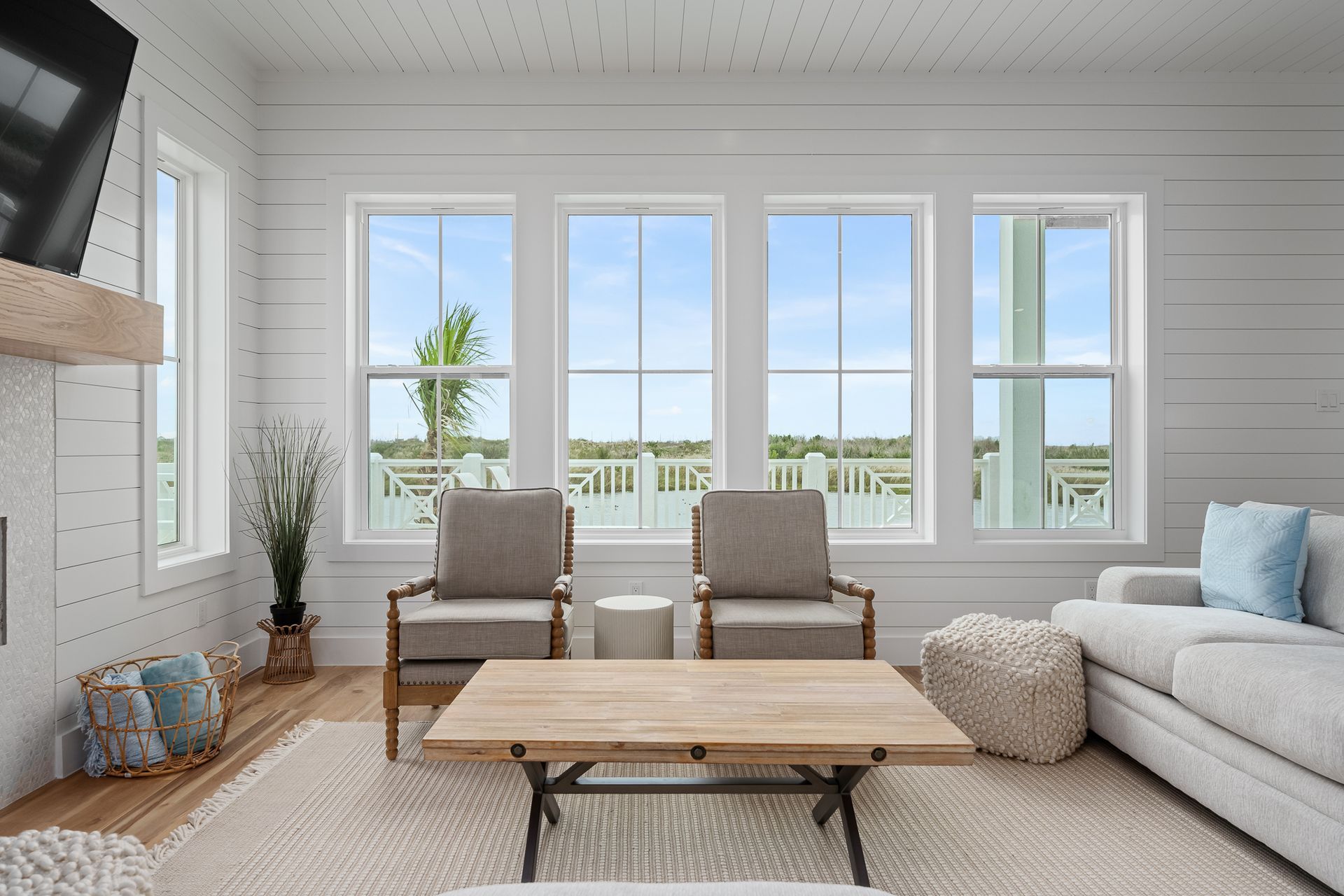 A living room with a couch , chairs , coffee table and television.