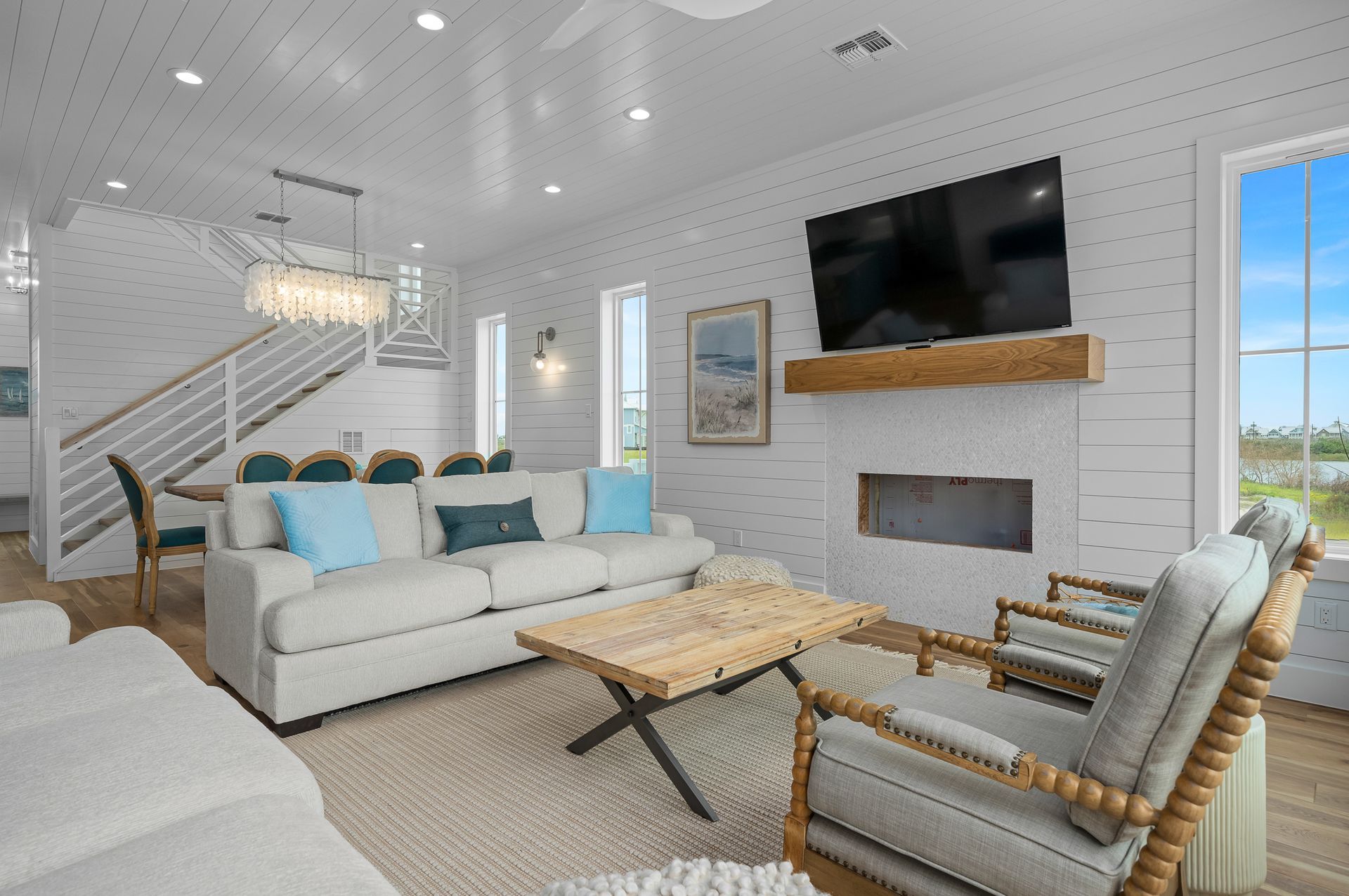 A living room with a couch , chairs , coffee table and television.