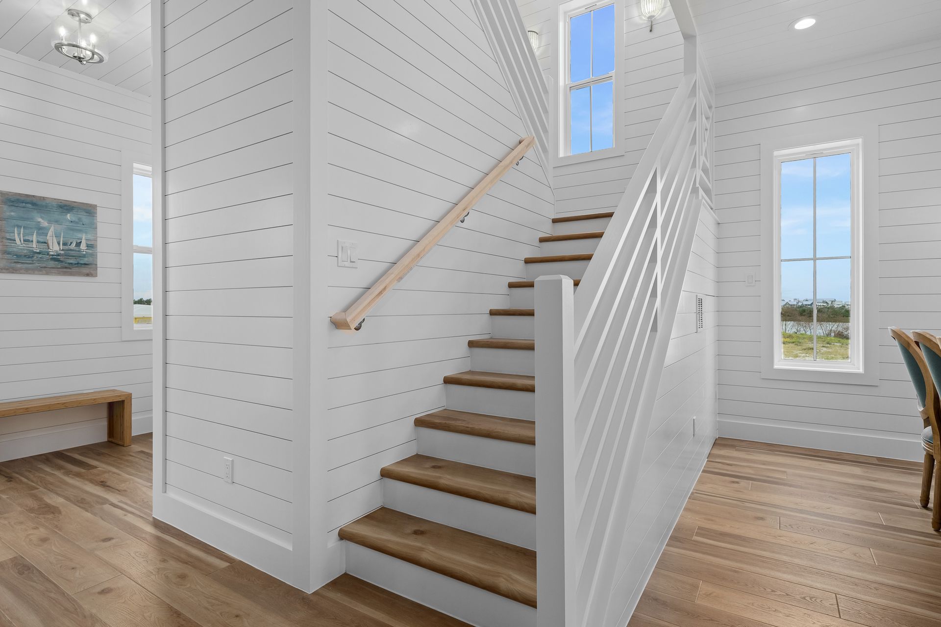 A white staircase with wooden steps and a white railing
