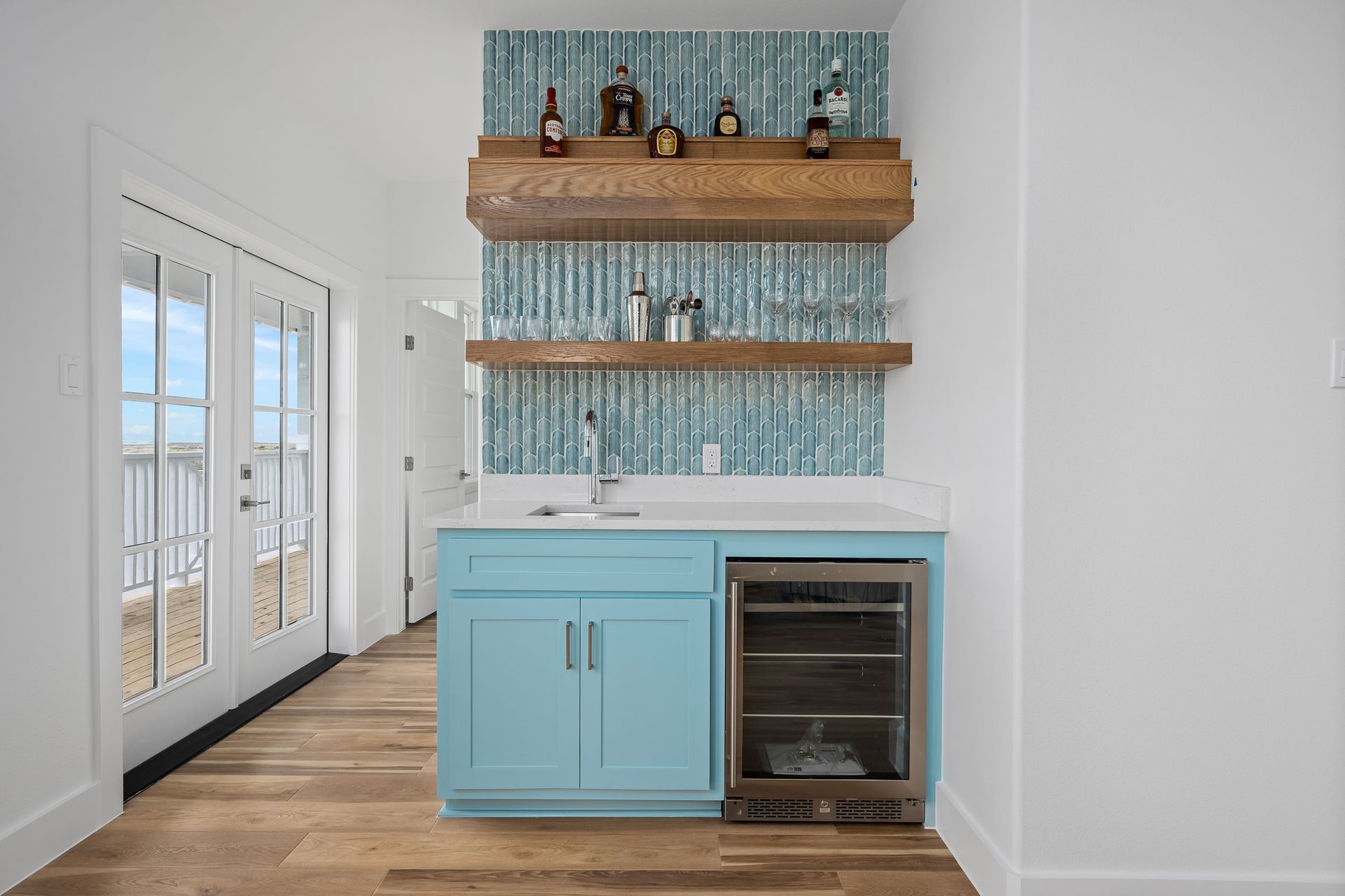 A kitchen with blue cabinets , a sink , and a refrigerator.