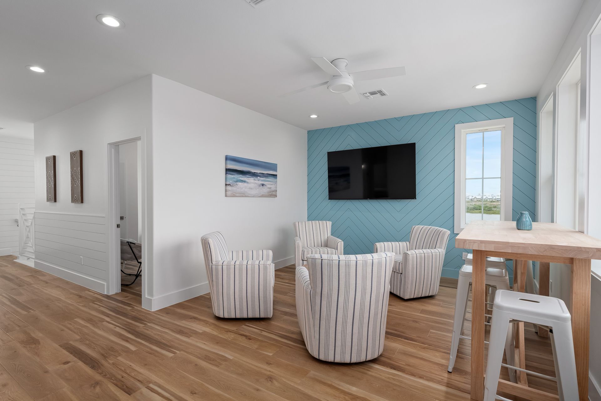 A living room with chairs , a table and a flat screen tv.