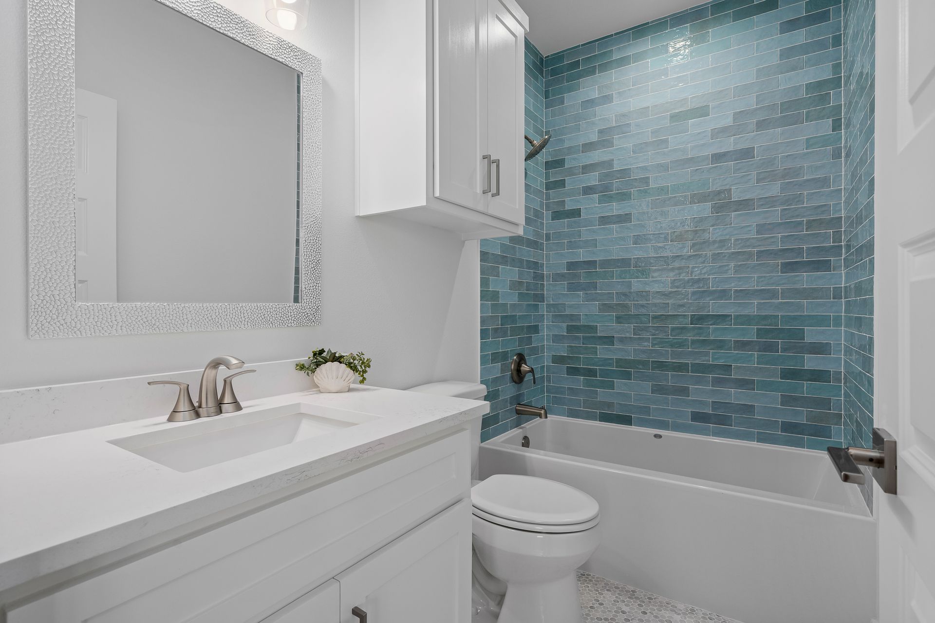 A bathroom with a sink , toilet , tub and mirror.