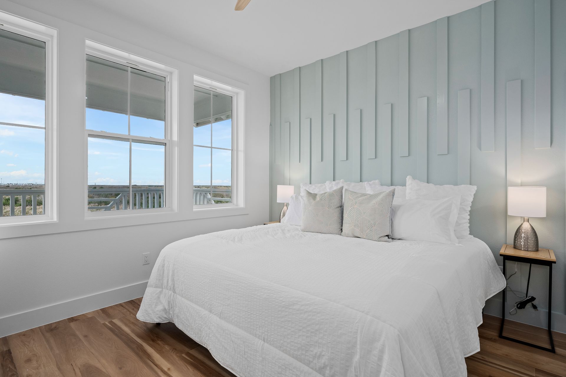 A bedroom with a large bed and lots of windows.