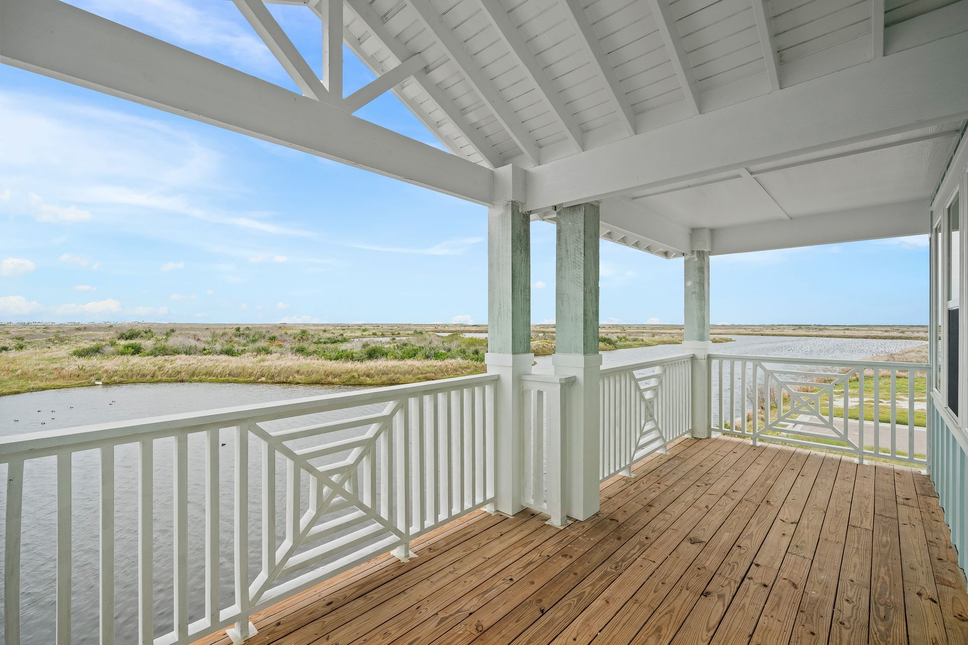 There is a large balcony with a view of the water.