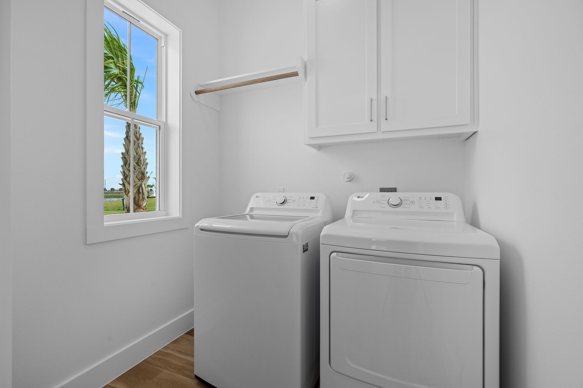 A laundry room with a washer and dryer and a window.