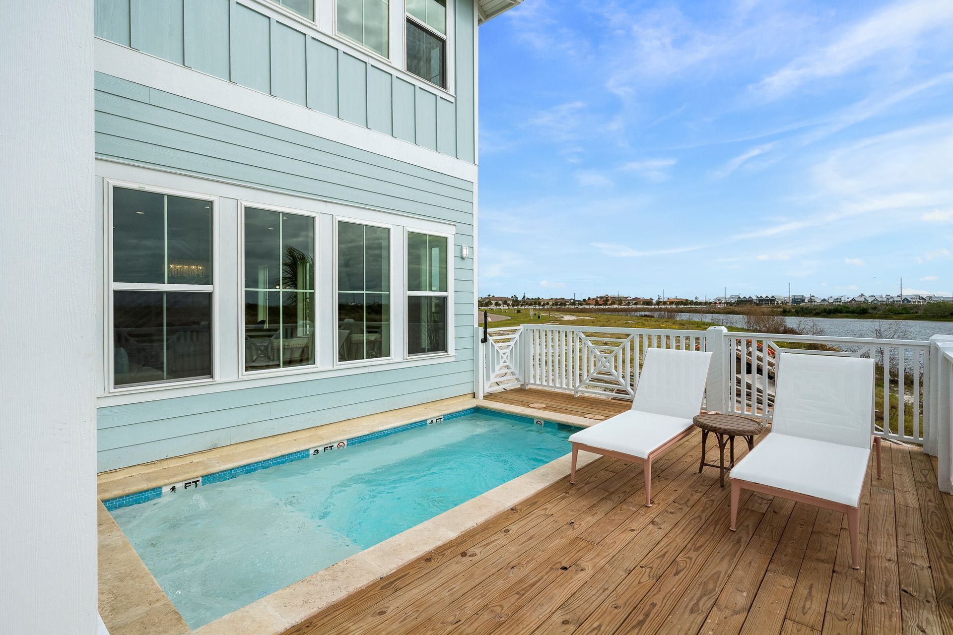 There is a large swimming pool in the backyard of a house.