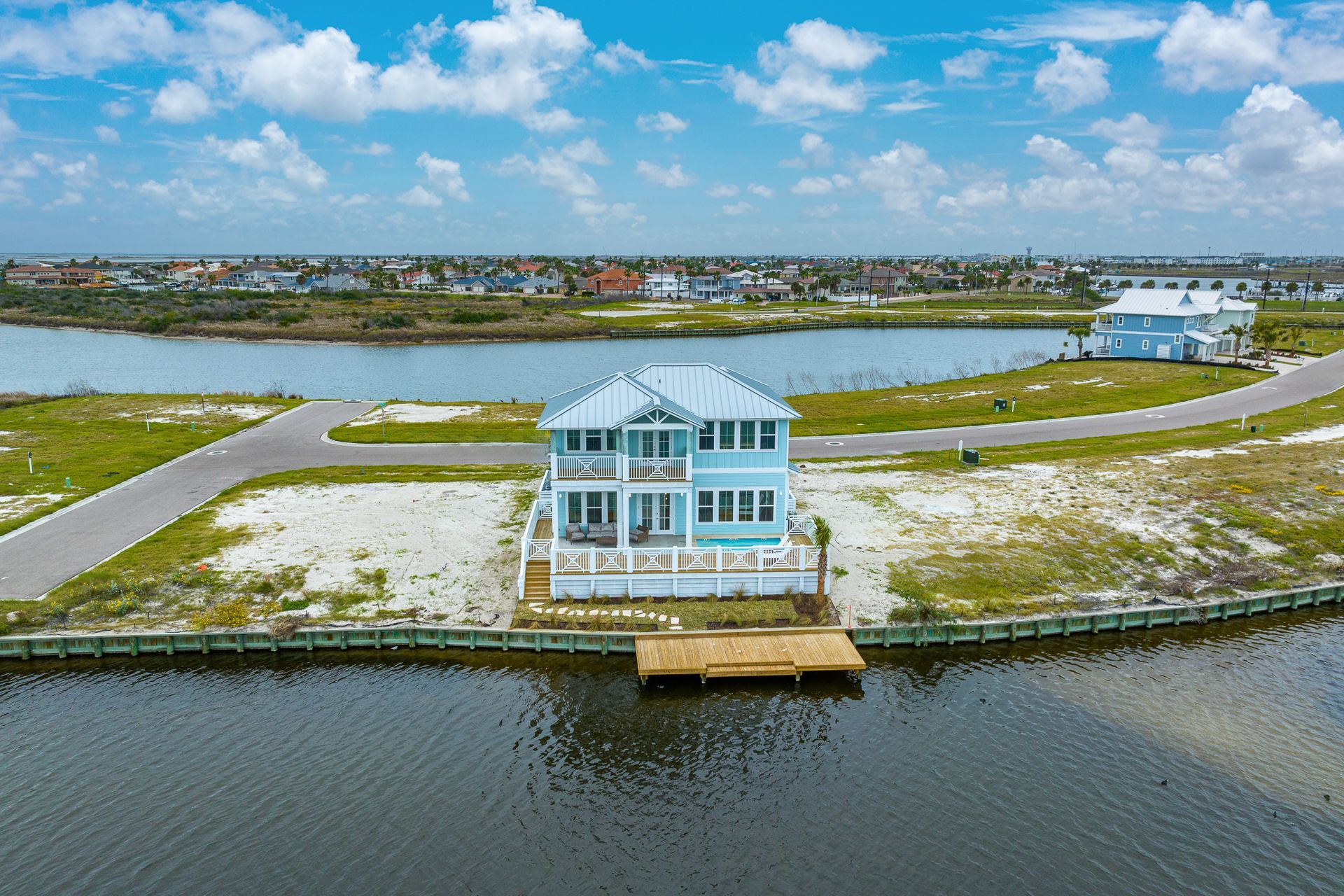 An aerial view of a house on a small island in the middle of a body of water.