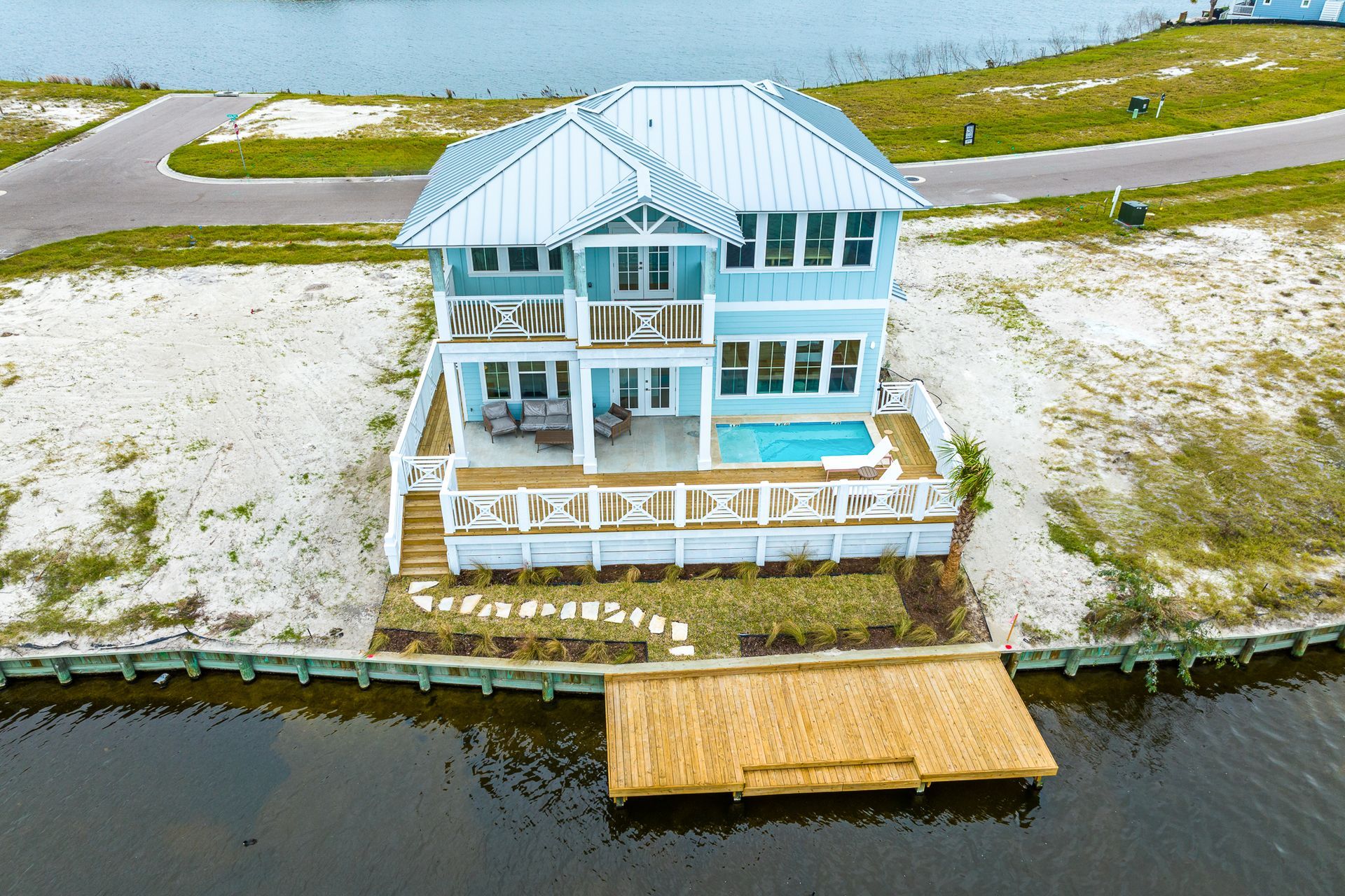 An aerial view of a house sitting on top of a body of water