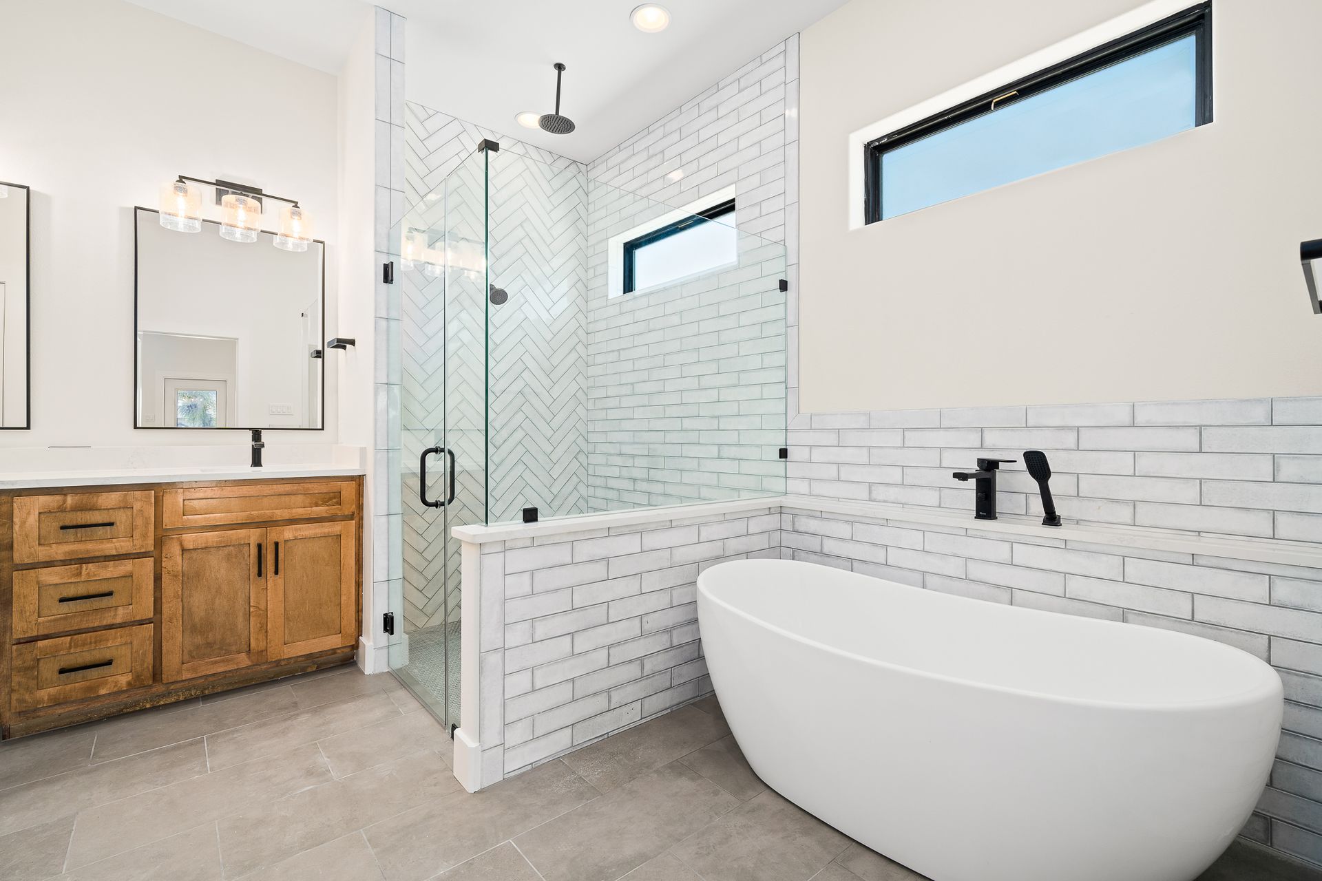A bathroom with two sinks , a tub and a shower.