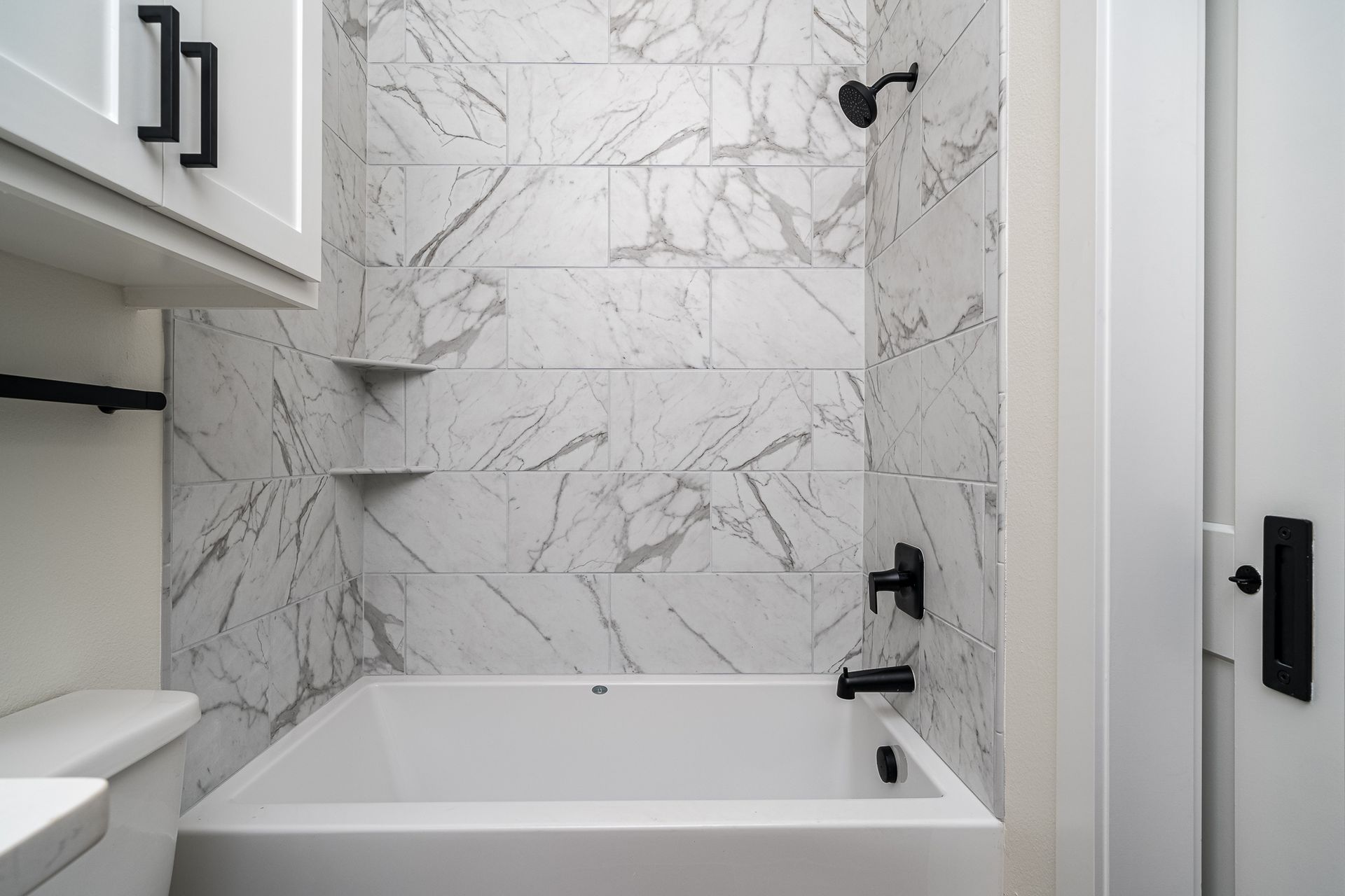 A bathroom with a bathtub , toilet , and shower.