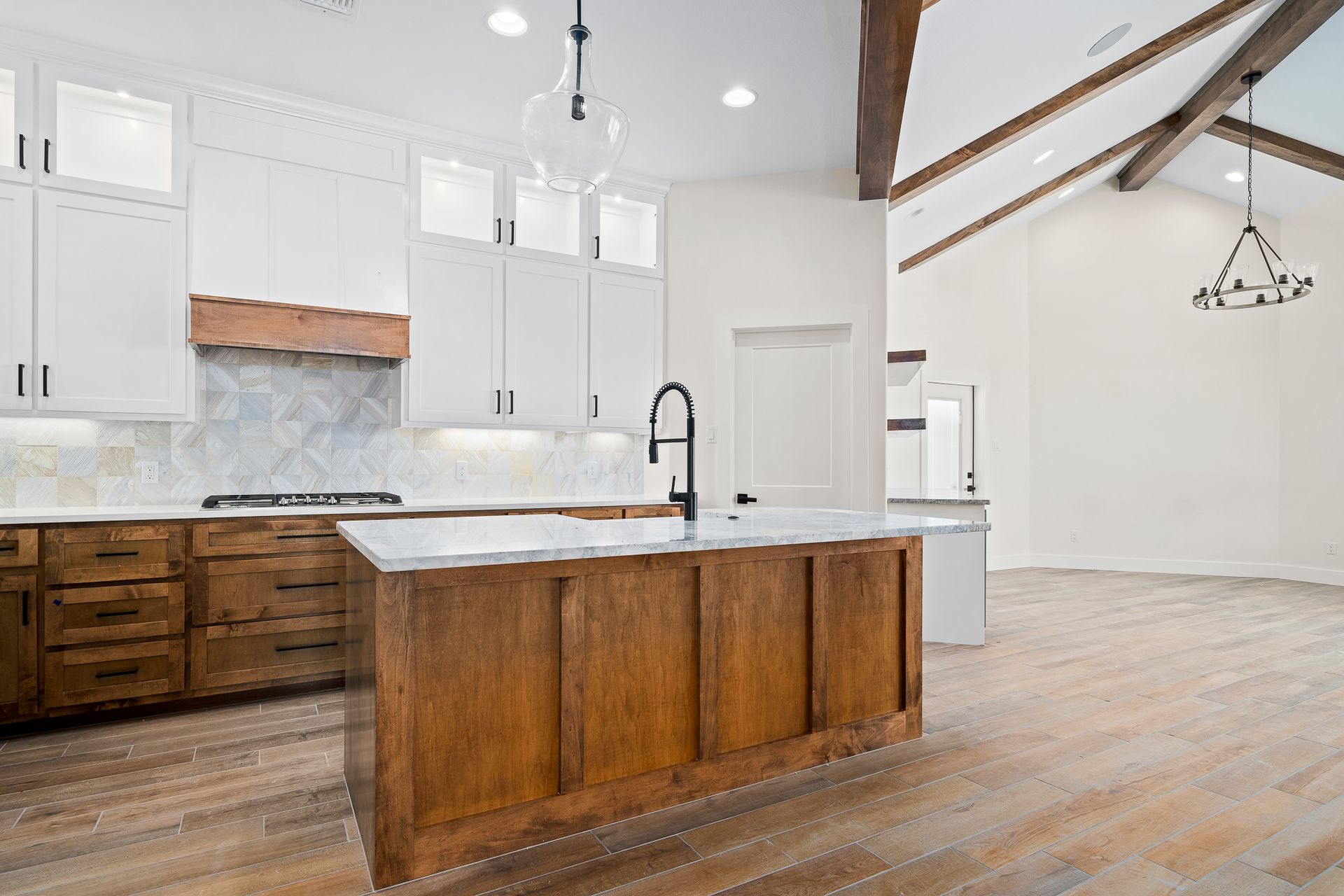 A kitchen with wooden cabinets and a large island in the middle.