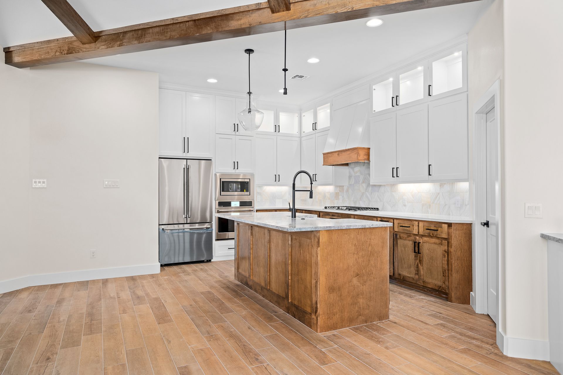 A kitchen with stainless steel appliances , wooden cabinets , and a large island.