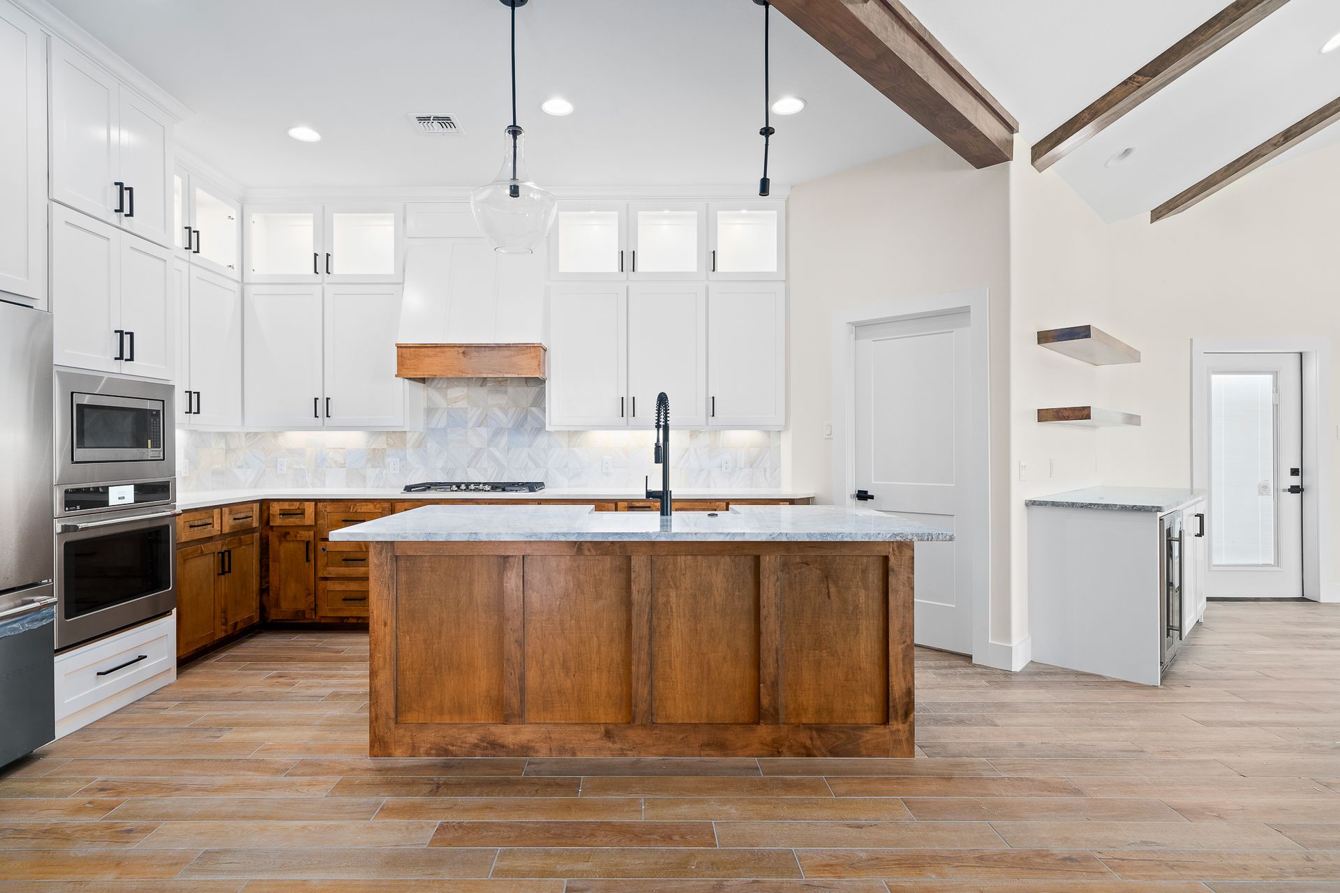 A kitchen with a large island in the middle and white cabinets.