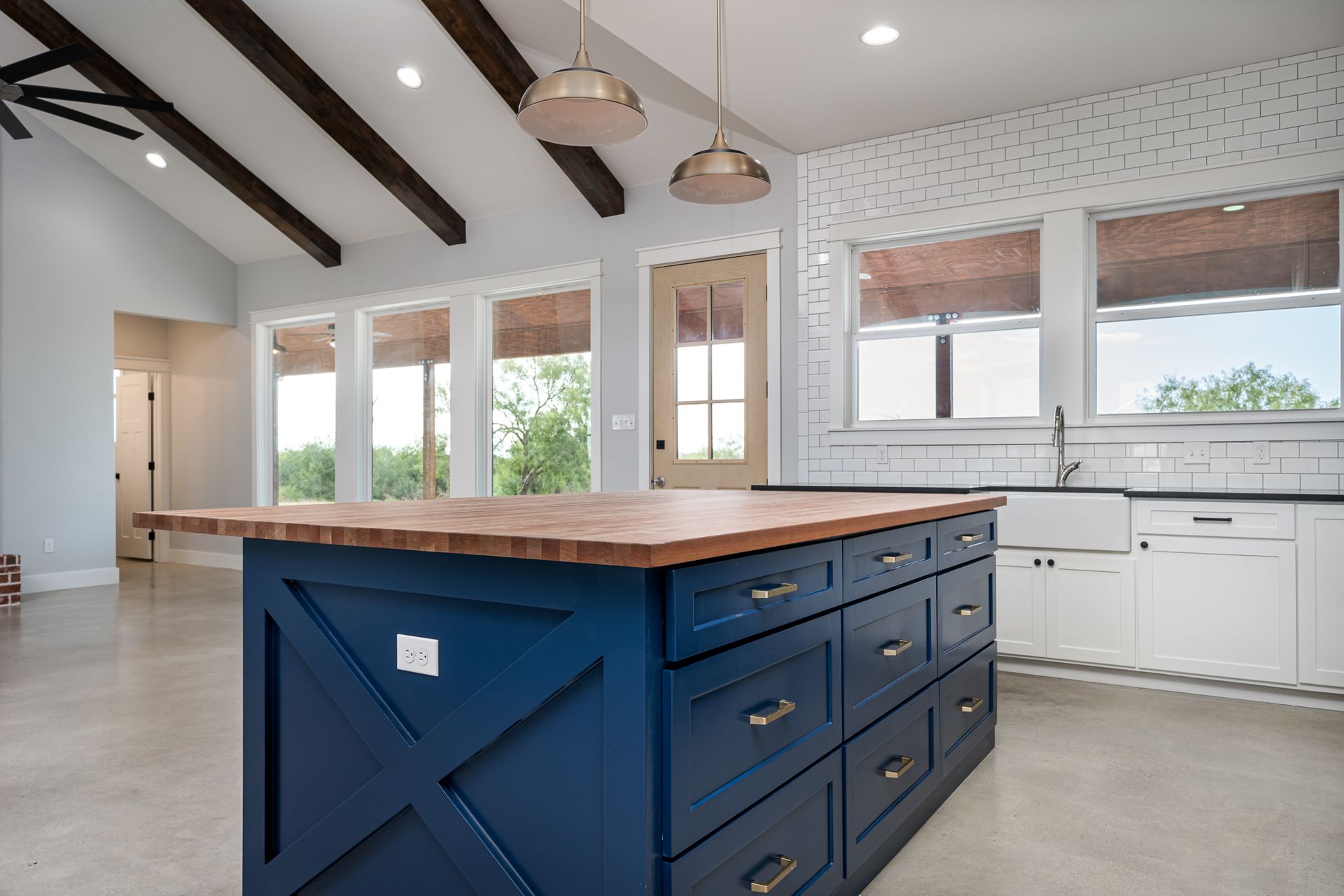 A kitchen with a large blue island and white cabinets